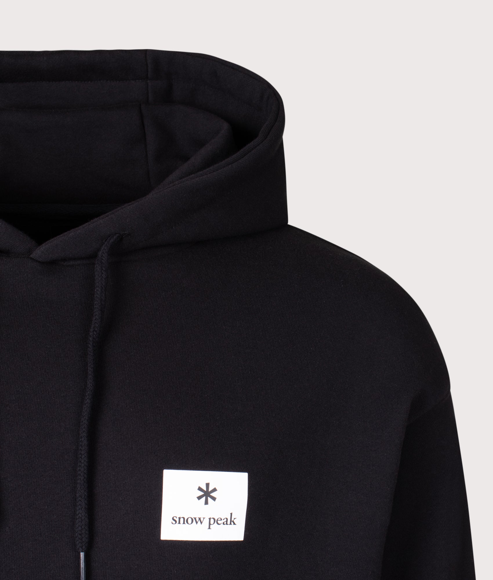 Snow Peak New Standard Square Logo Hoodie in black at EQVVS Menswear. Detail shot.