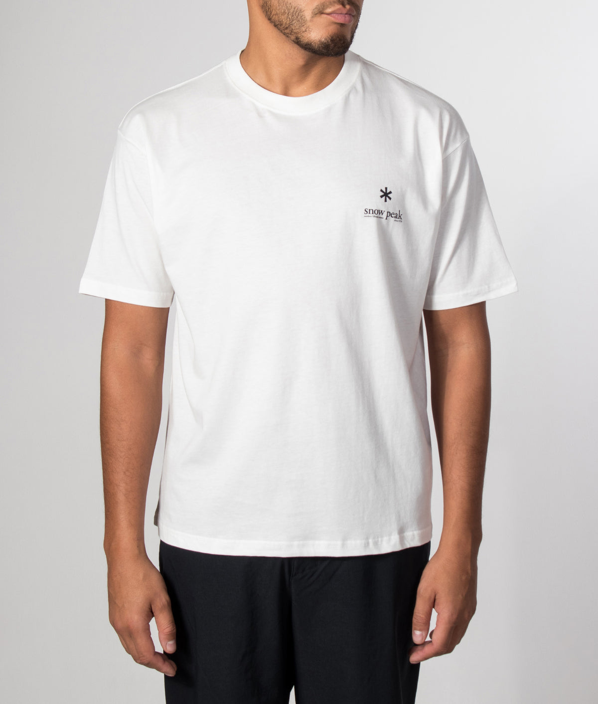 Snow Peak Relaxed Fit Soft Cotton Logo T-Shirt in Off White at EQVVS Menswear. Model front shot.