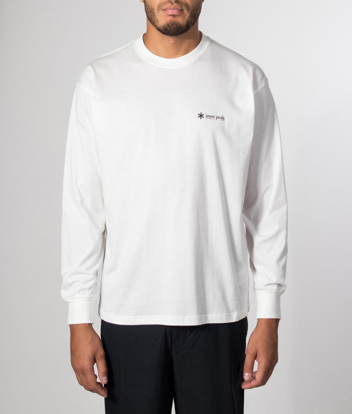 Snow Peak Relaxed Fit Long Sleeve Logo T-Shirt in Off White at EQVVS Menswear.  Model front shot.