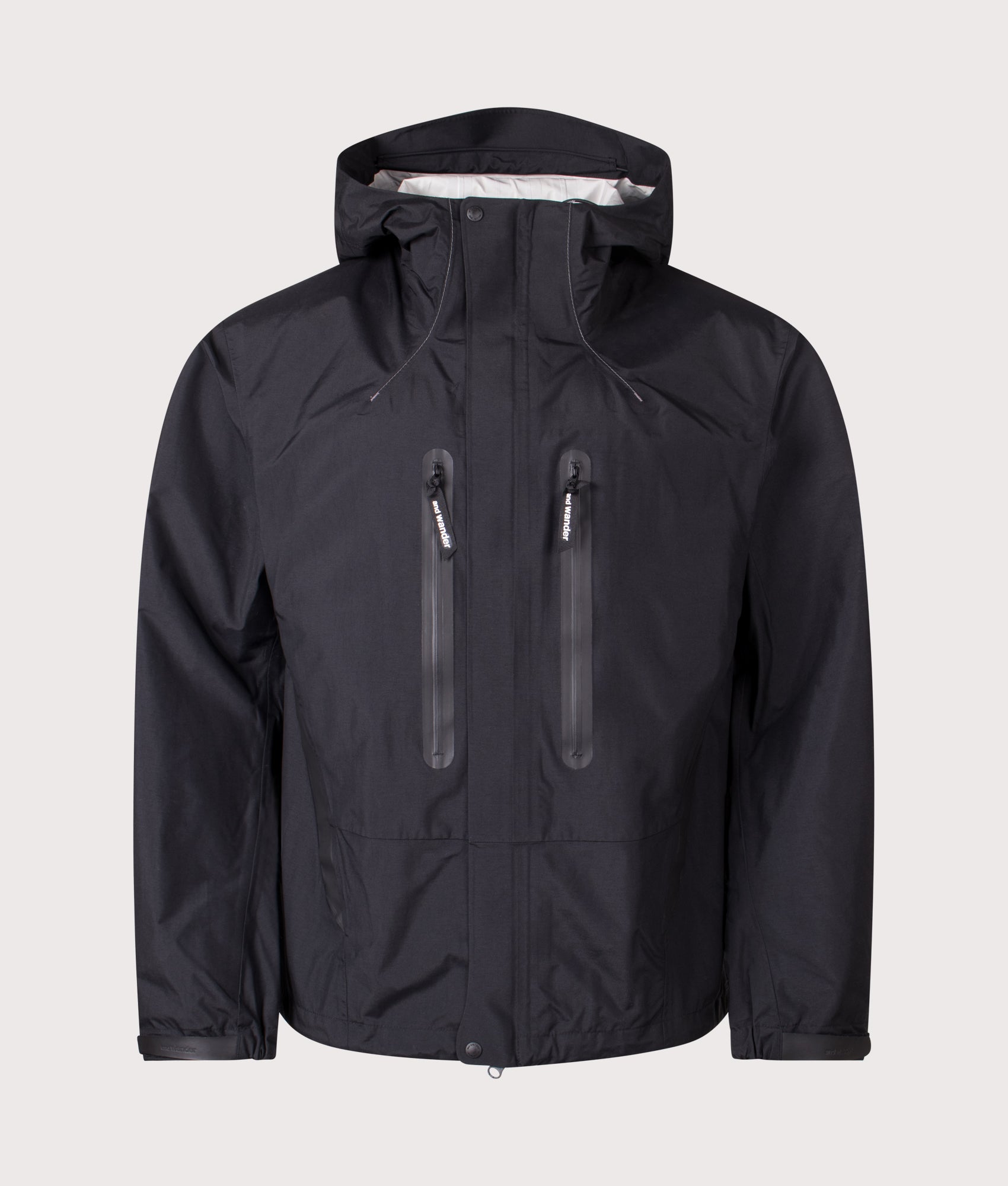 And Wander 2.5L Hiker Rain Jacket in Black at EQVVS Menswear. Front shot.