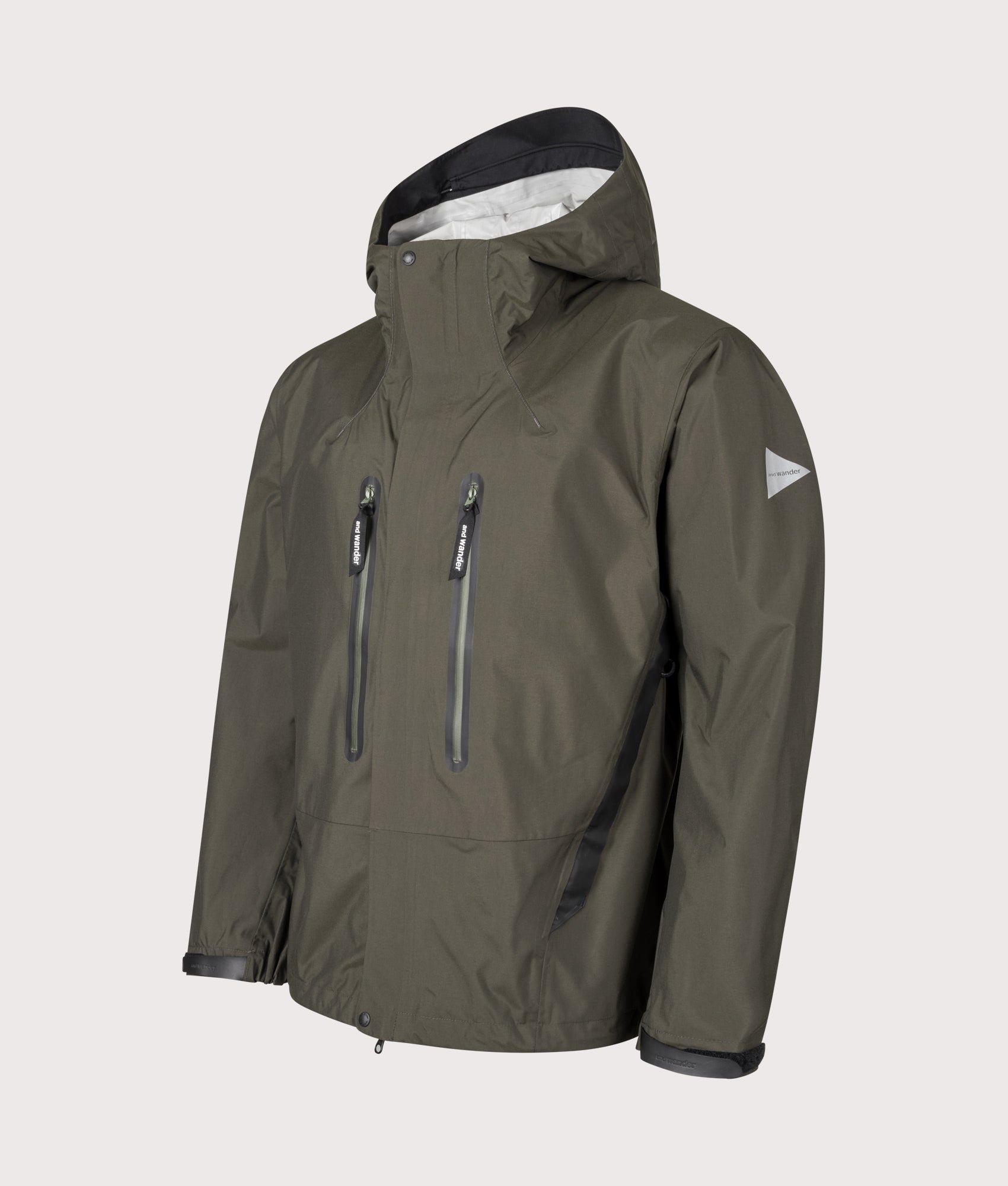 And Wander 2.5L Hiker Rain Jacket in Khaki at EQVVS Menswear. Angled front shot.