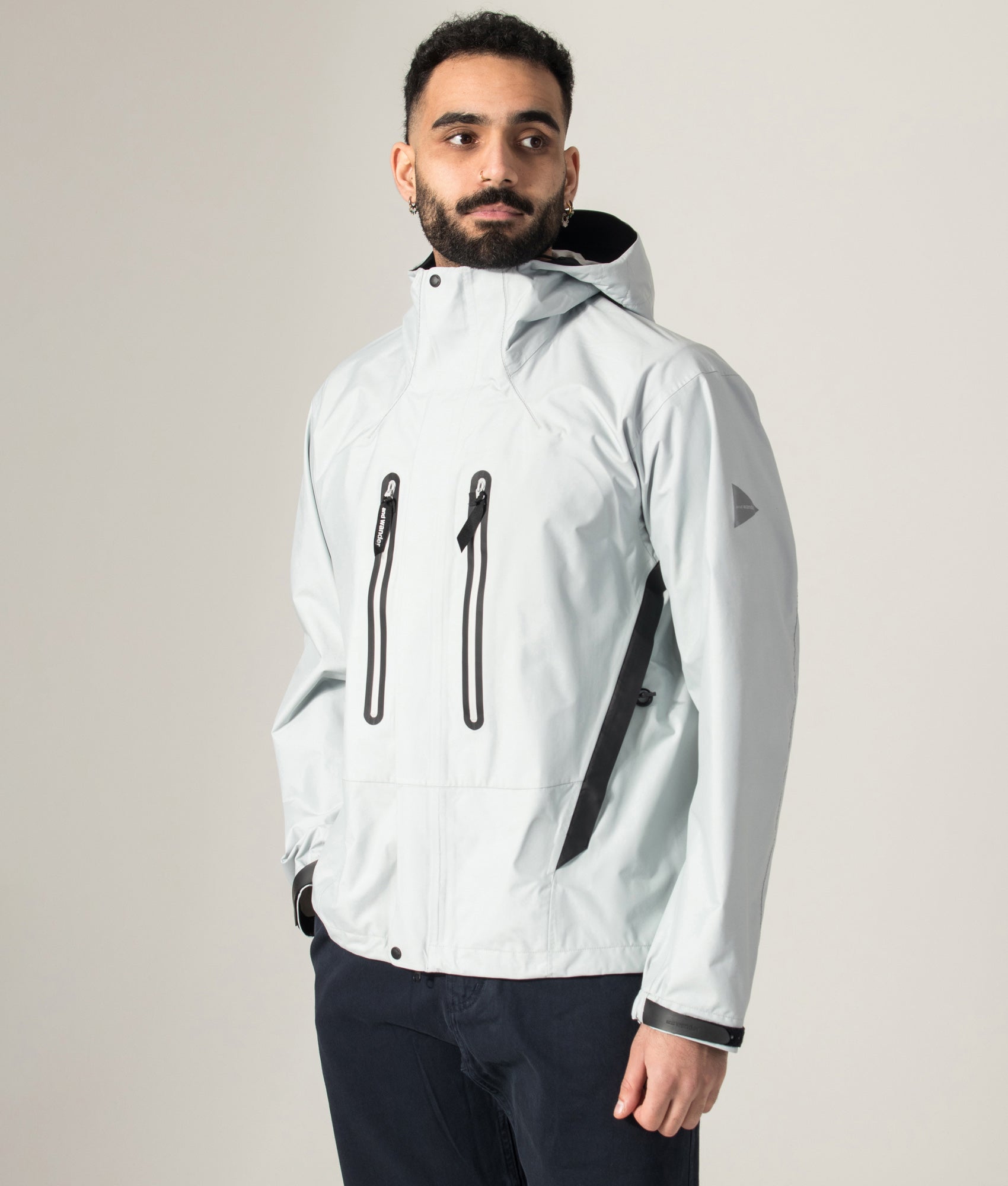 2.5L Hiker Rain Jacket in Light Grey by and wander. Shot by EQVVS. Model angled shot.