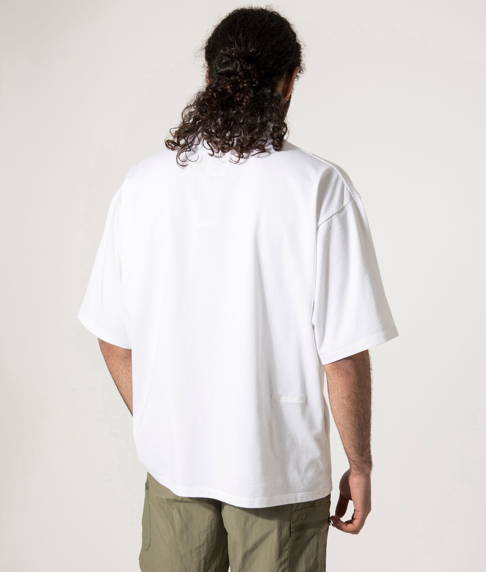 nanamica Mock Neck T-Shirt in white at EQVVS. Model Back Shot.