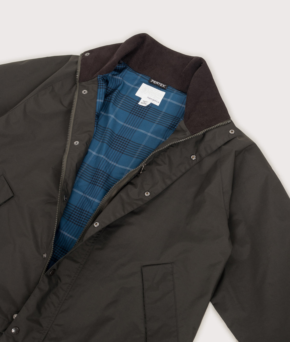 nanamica 2L PERTEX UNLIMITED Short Field Jacket in Dark Olive at EQVVS Menswear. Detail shot.