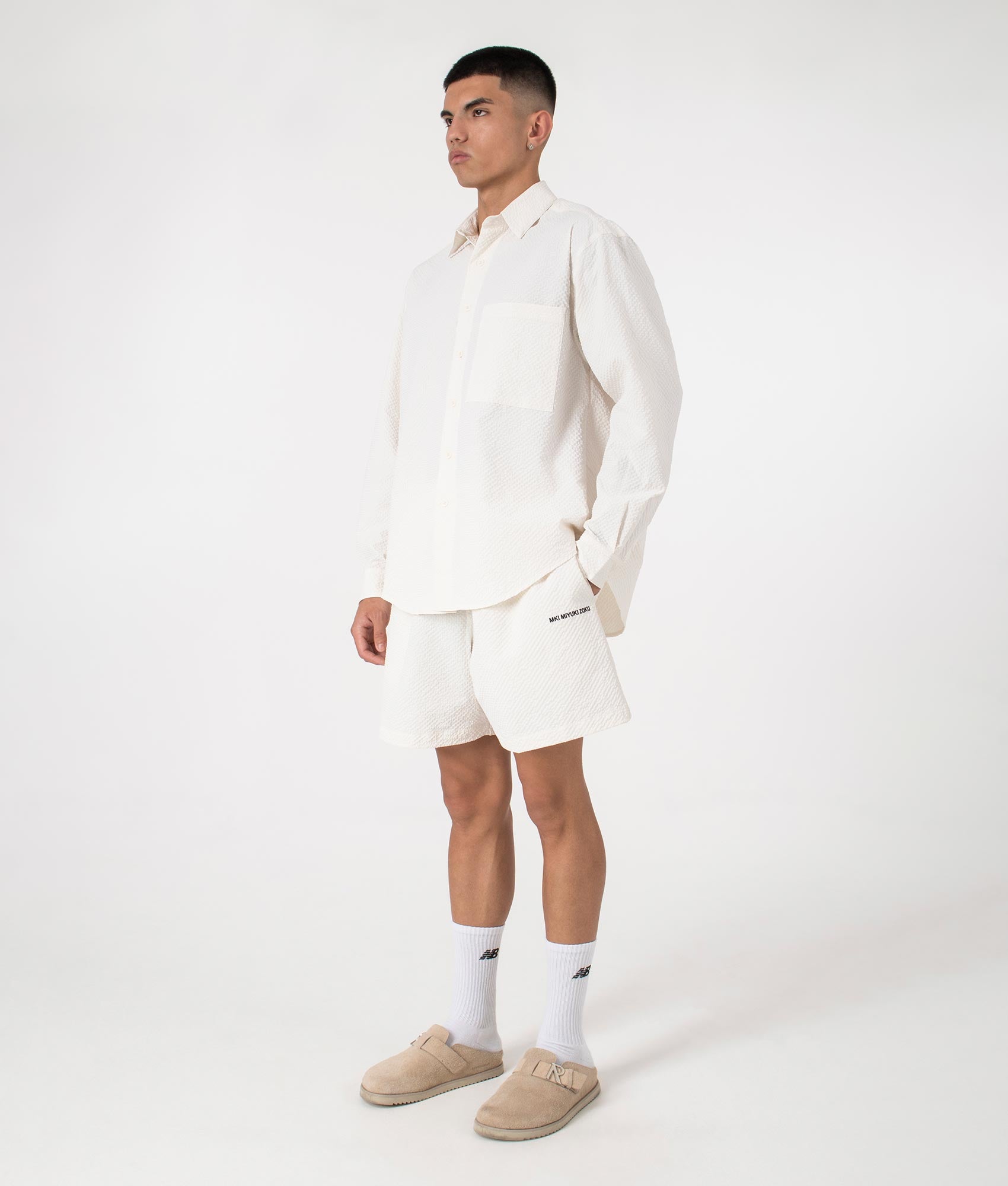 MKI Relaxed Fit Seersucker Shorts in Off White. Full side angle model shot at EQVVS.