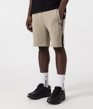 Fred Perry Taped Sweat Shorts in Warm Grey/Brick with side tape detail. Side angle shot at EQVVS.