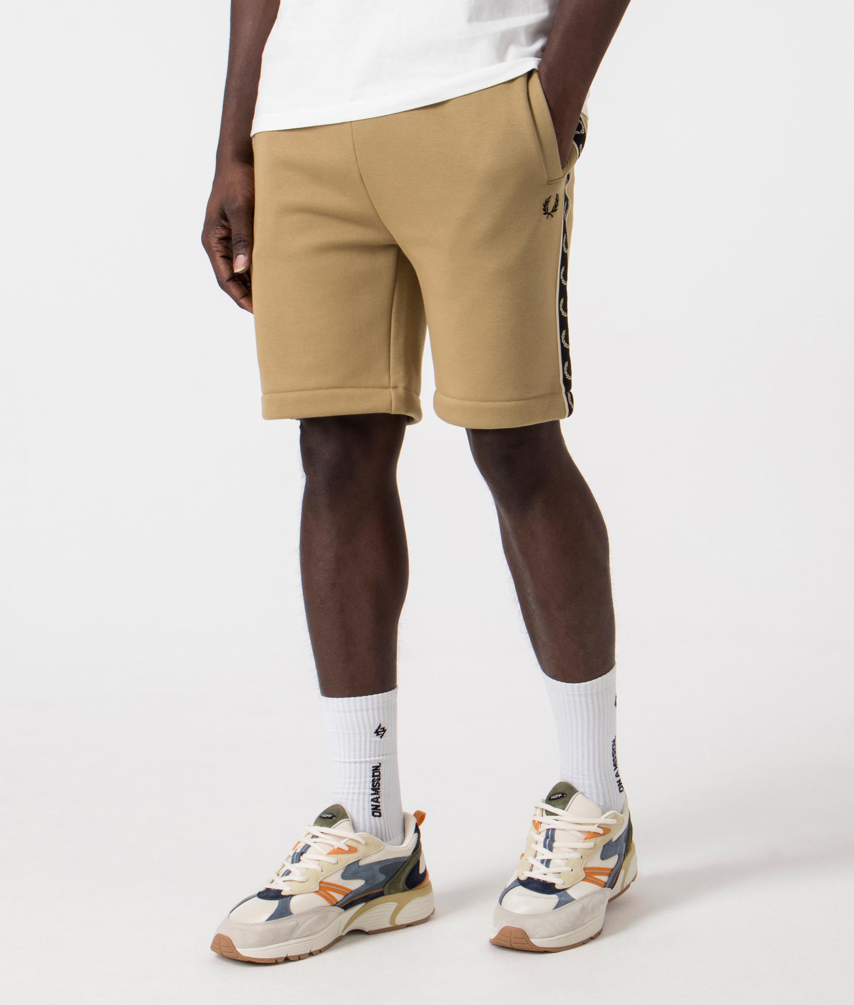 Fred Perry Taped Sweat Short in Warm Stone/Oatmeal with side taping detail. Side angle shot at EQVVS.