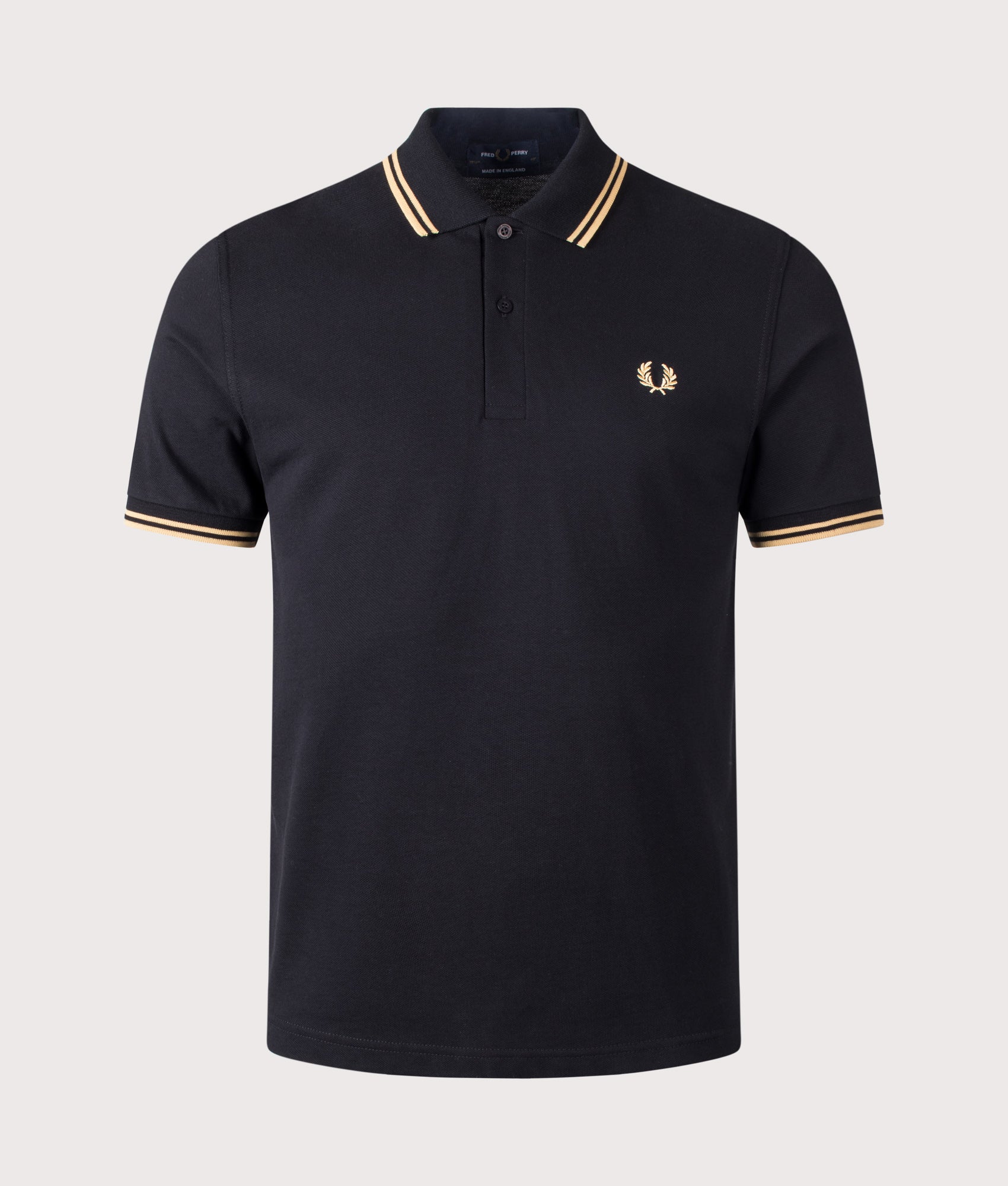 Fred Perry M12 Twin Tipped Fred Perry Polo Shirt in Black and Champagne at EQVVS Menswear. Front shot.
