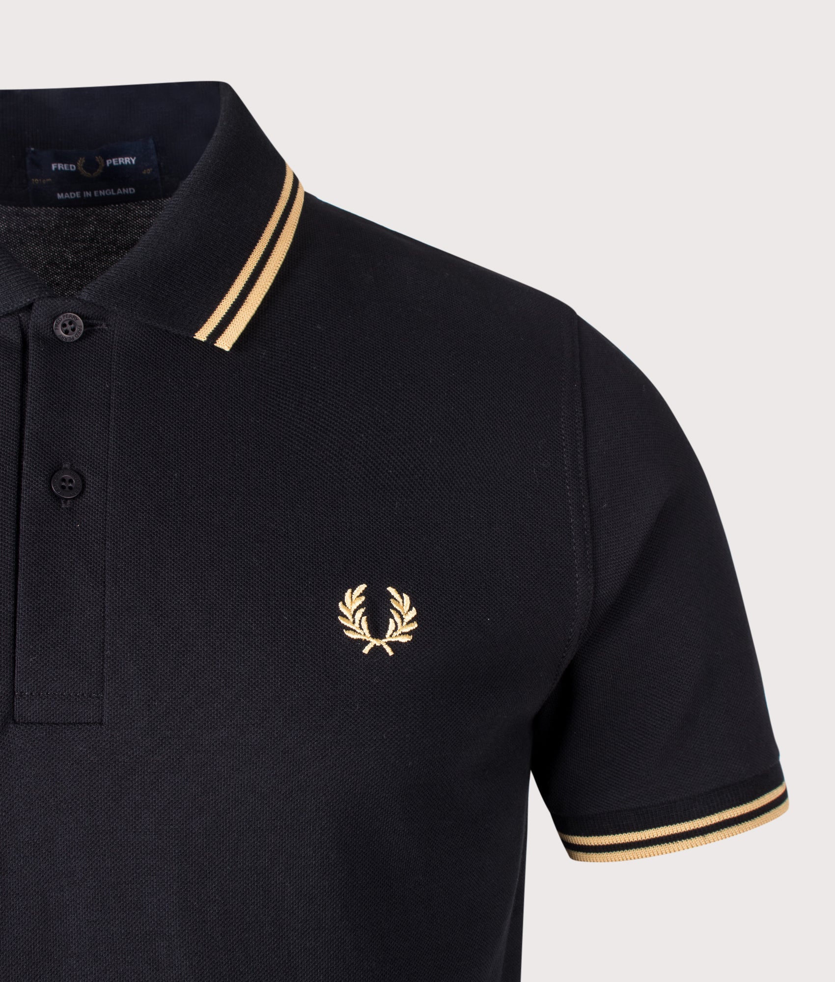 Fred Perry M12 Twin Tipped Fred Perry Polo Shirt in Black and Champagne at EQVVS Menswear. Detail shot.