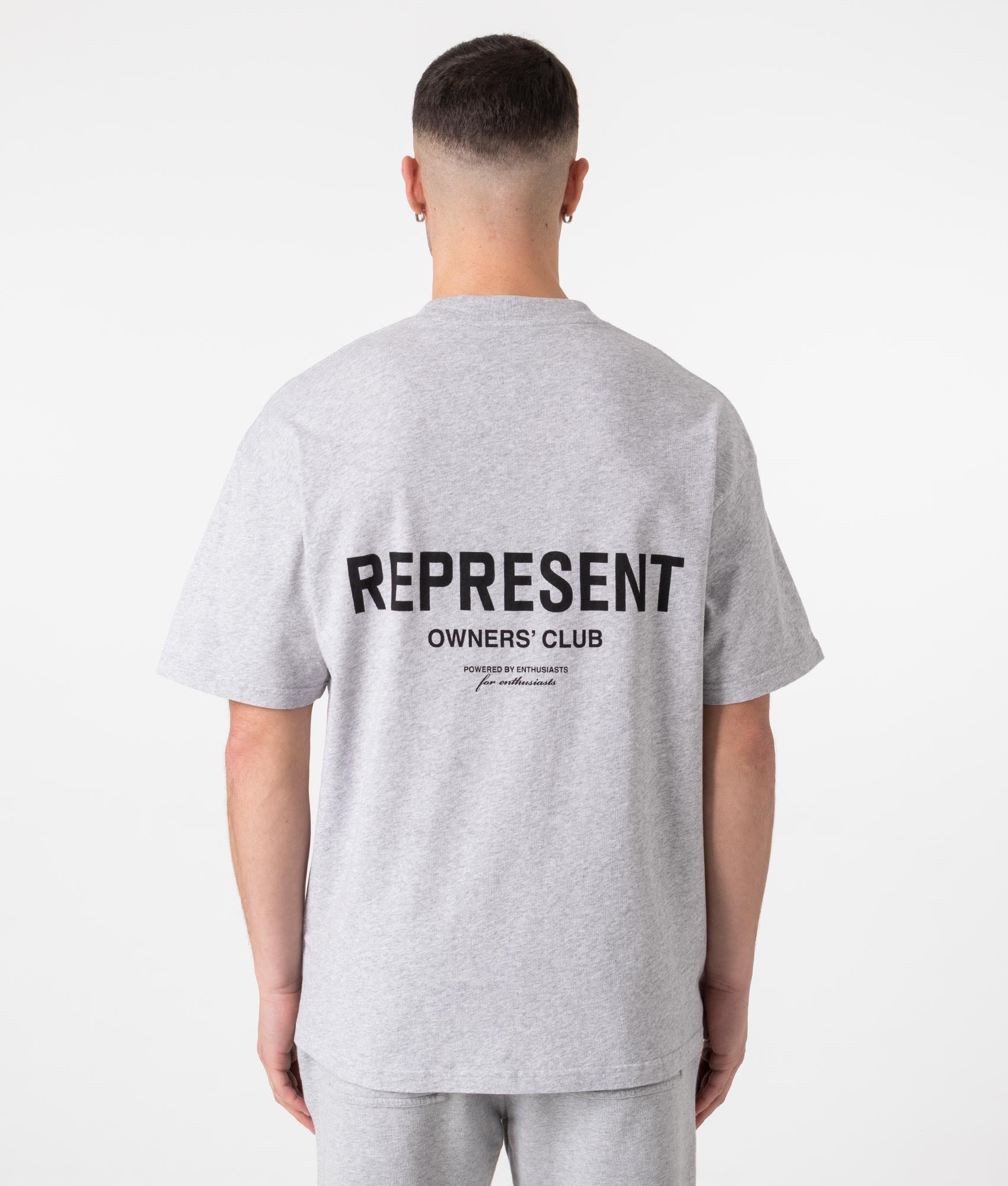 Represent Oversized Fit Owners Club T-Shirt in Grey at EQVVS Menswear. Model back shot.