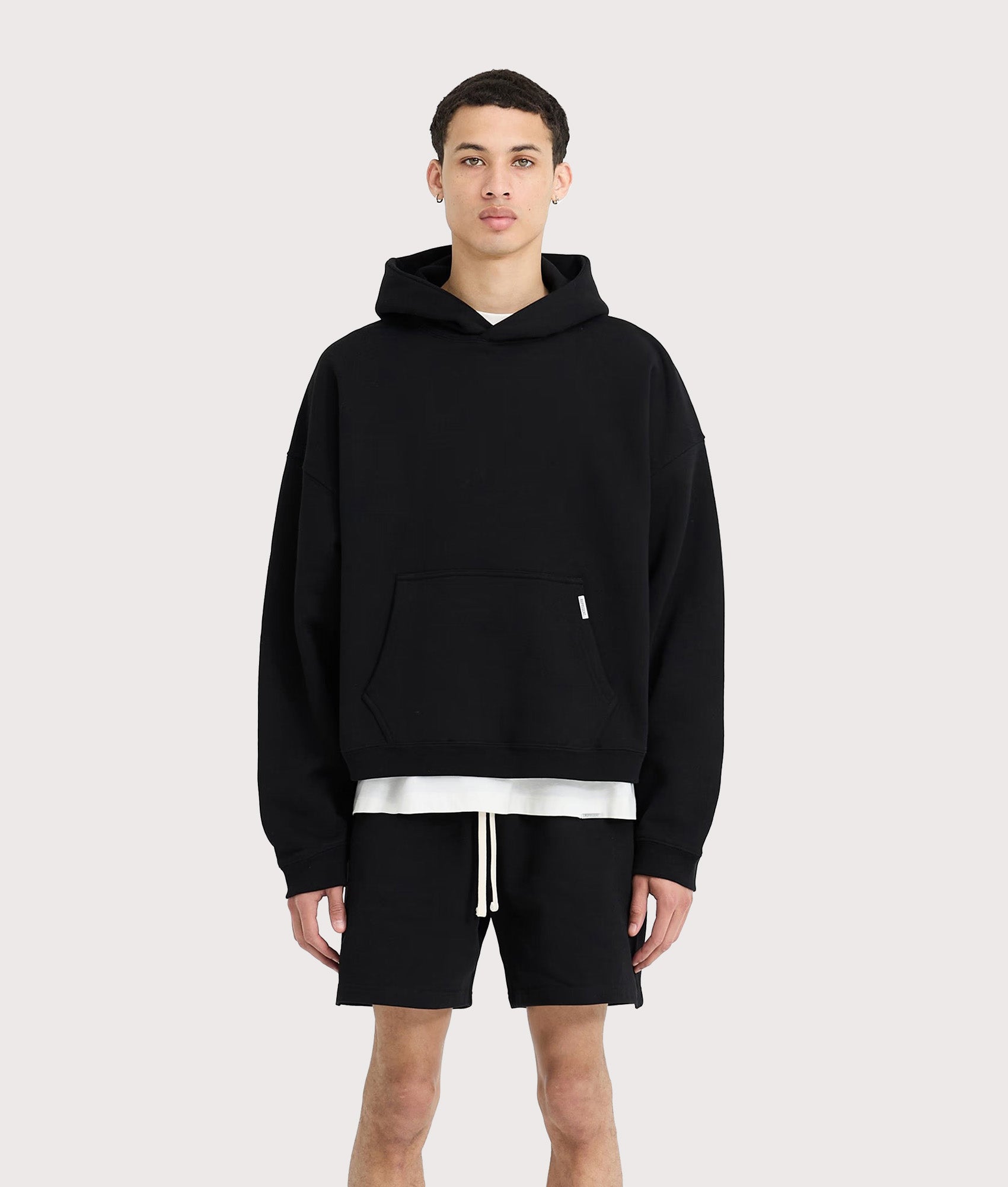 REPRESENT Initial Boxy Oversized Hoodie in black at EQVVS Menswear. Model front shot.