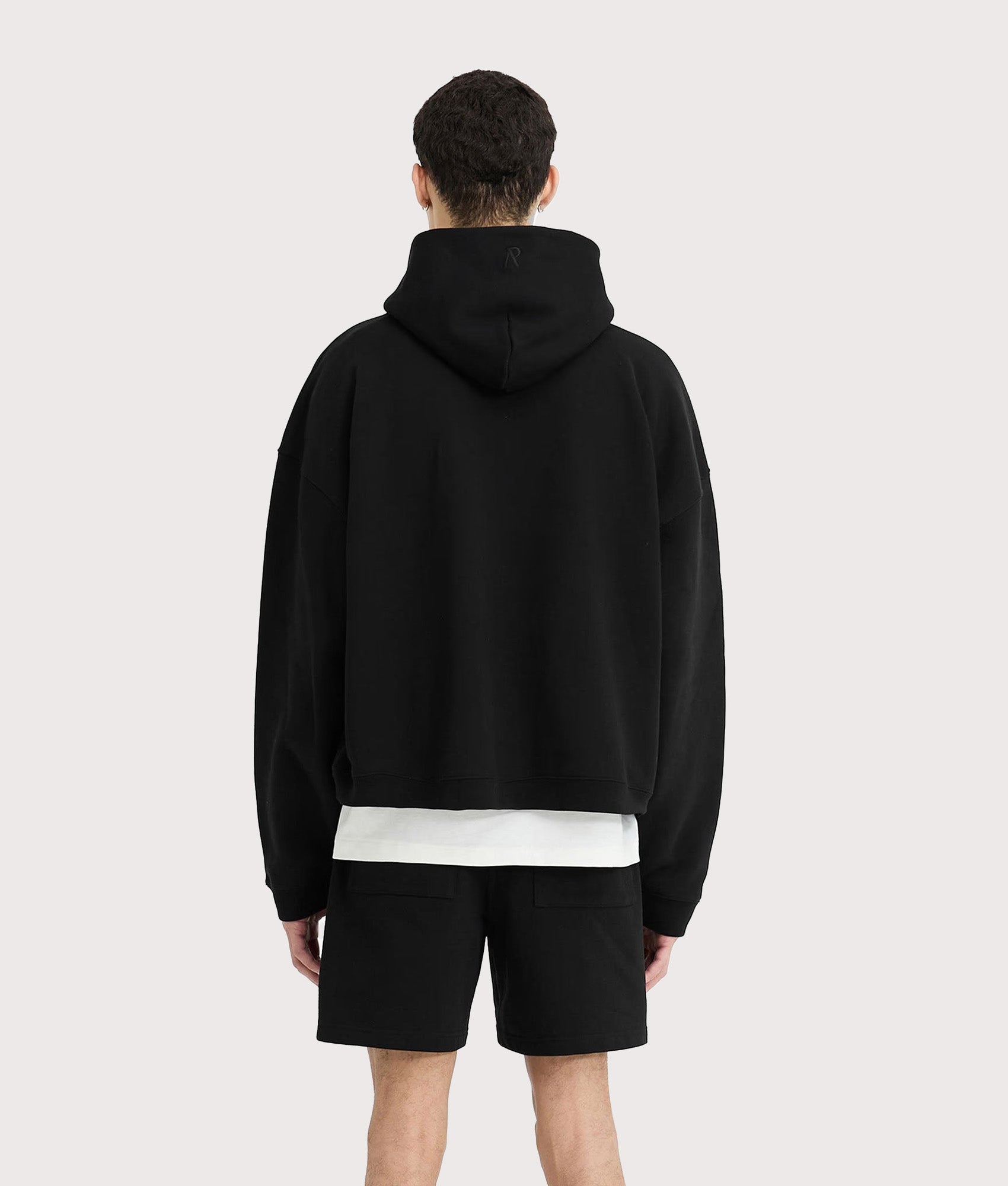 REPRESENT Initial Boxy Oversized Hoodie in black at EQVVS Menswear. Model back shot.