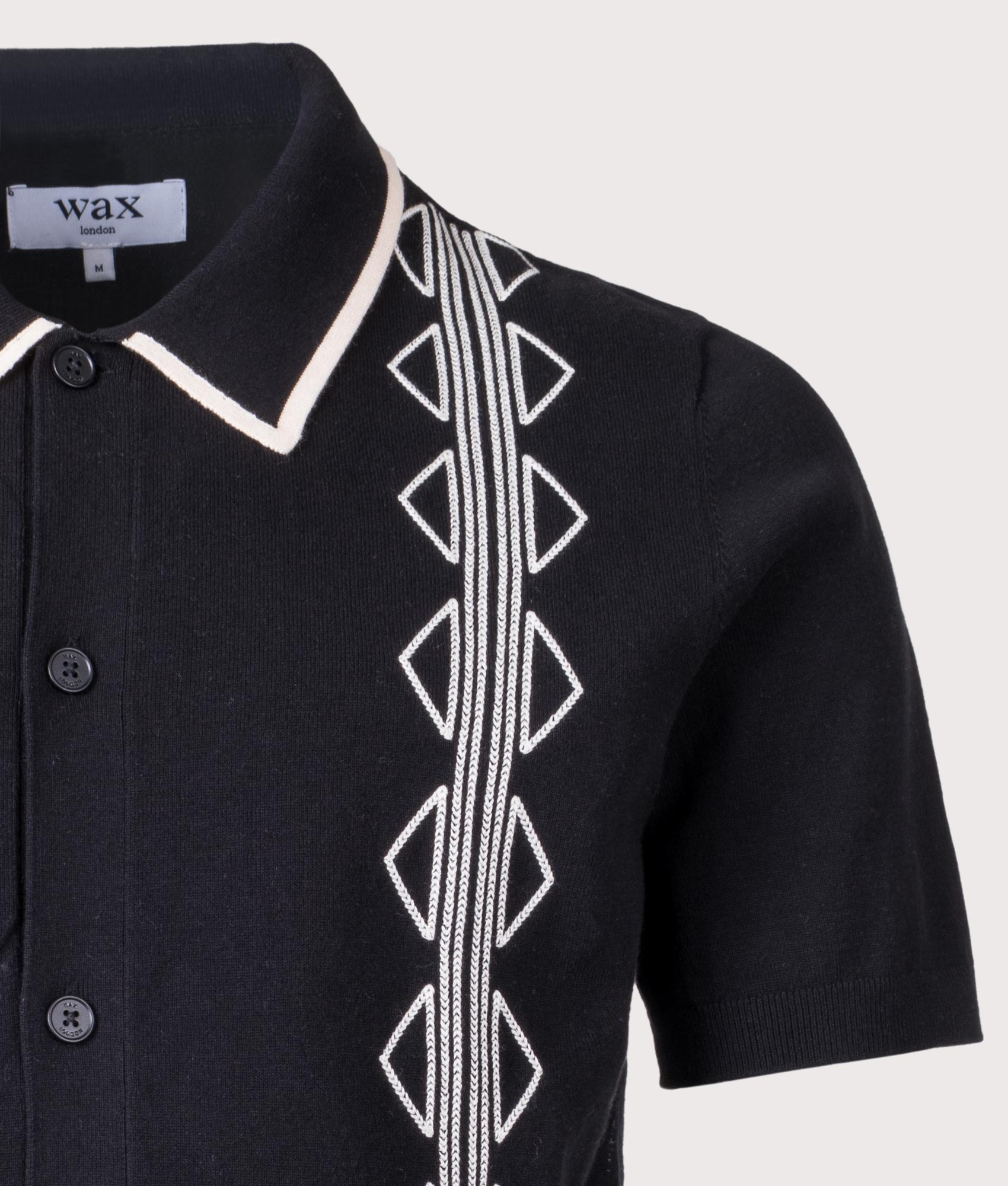 Tellaro Retro Embroidery Polo Shirt in Black/Ecru by Wax London. Shot by EQVVS. Detail shot.