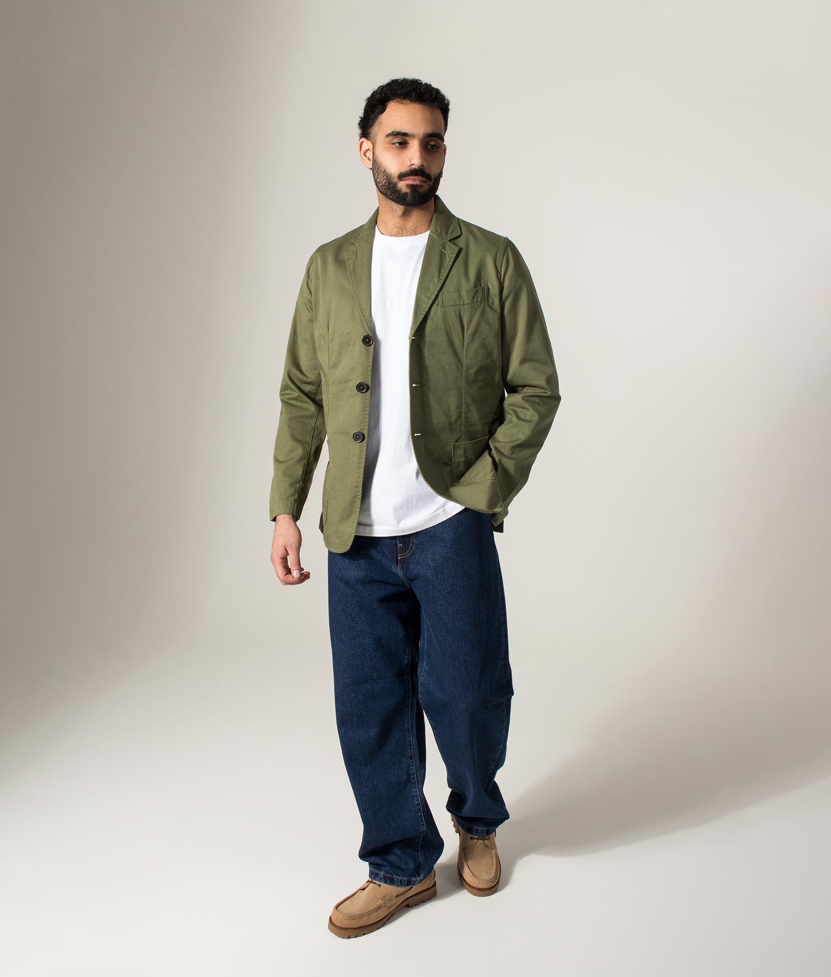 Universal Works Slim Fit Twill London Jacket in Light Olive at EQVVS Menswear. Model full length shot.