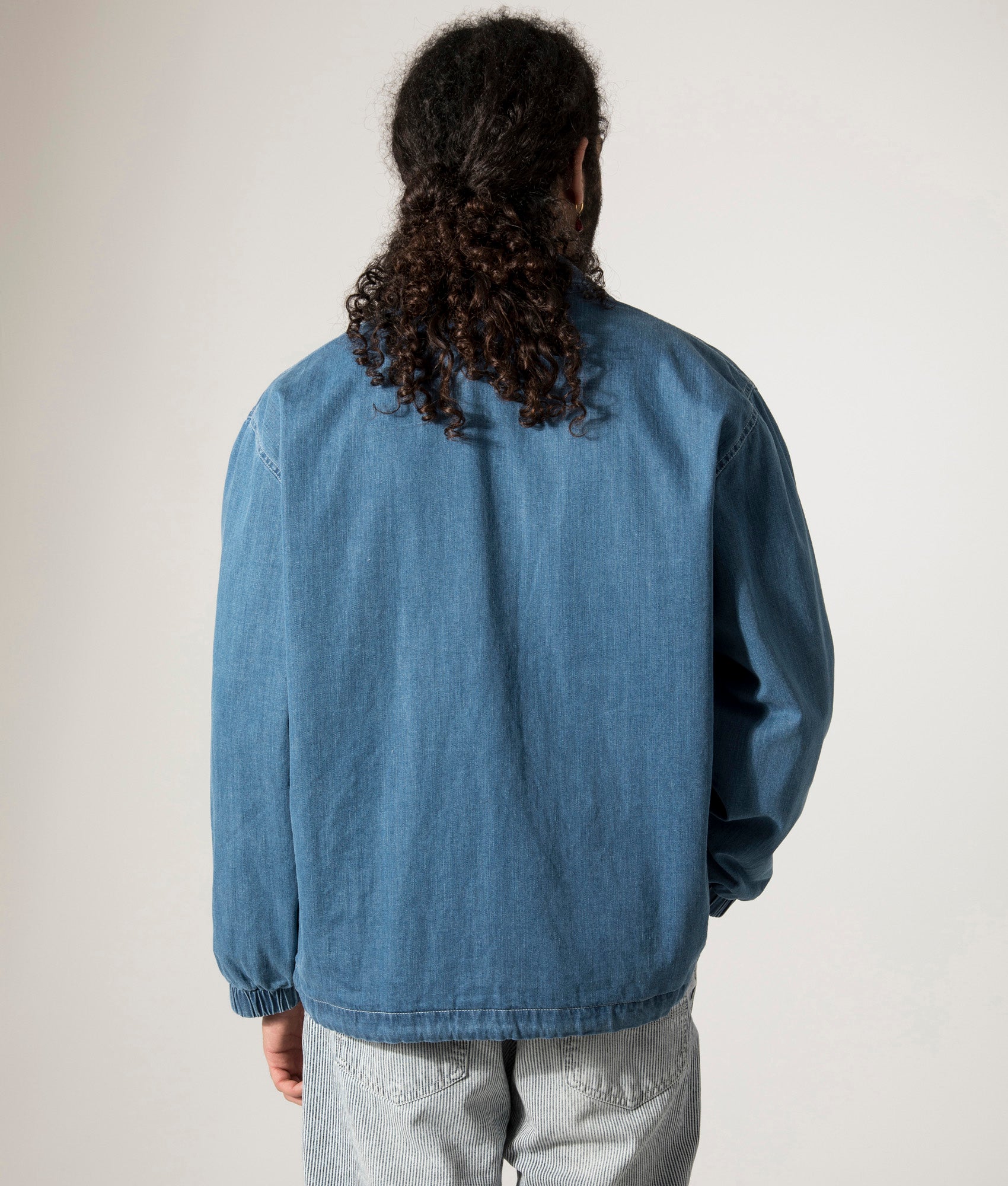 Universal Works Head Coach Jacket in Washed Indigo. Shot at EQVVS. Model back shot. 