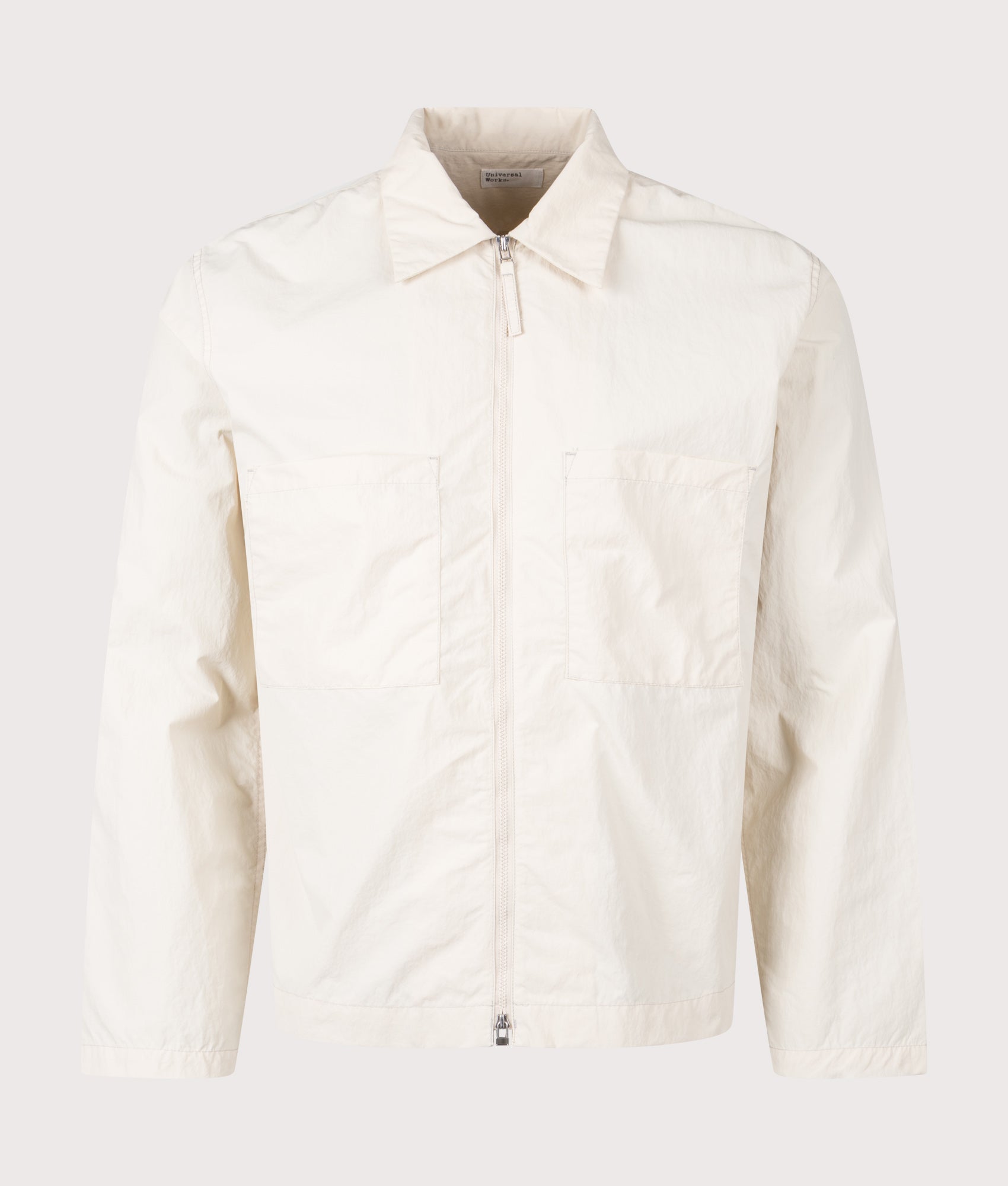 Universal Works Seo Recycled Nylon Zip Too Overshirt in Stone at EQVVS Menswear. Front shot.