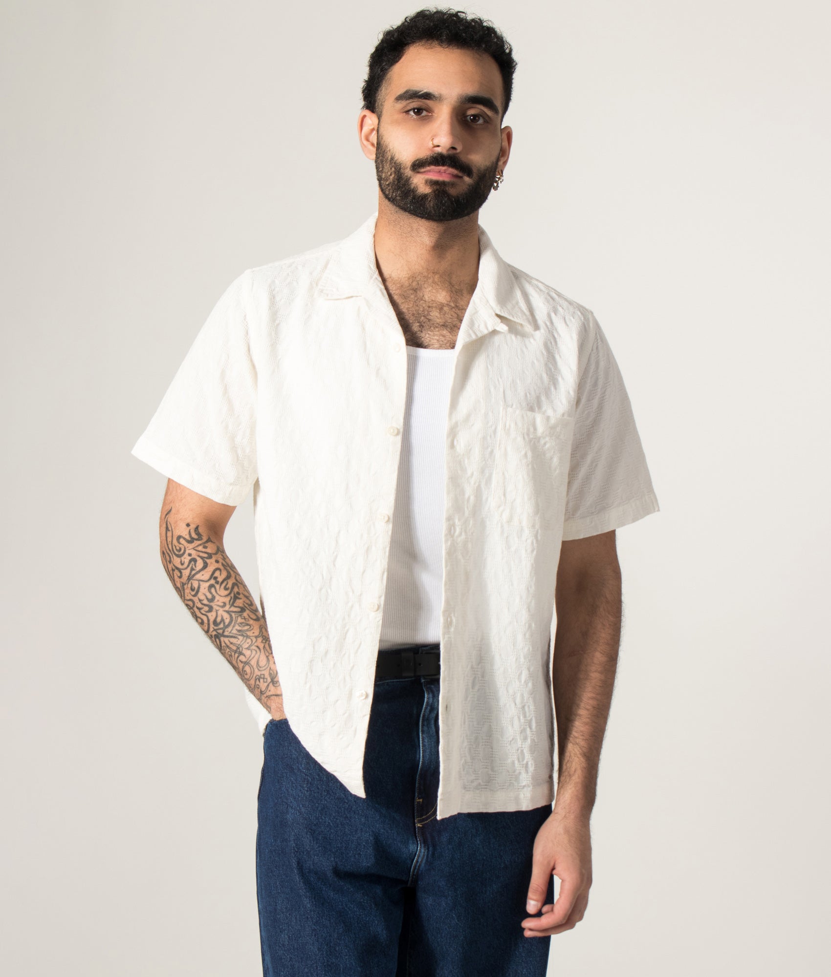 Universal Works Short Sleeve Seersucker Road Shirt in Ecru at EQVVS Menswear. Model open shirt shot.