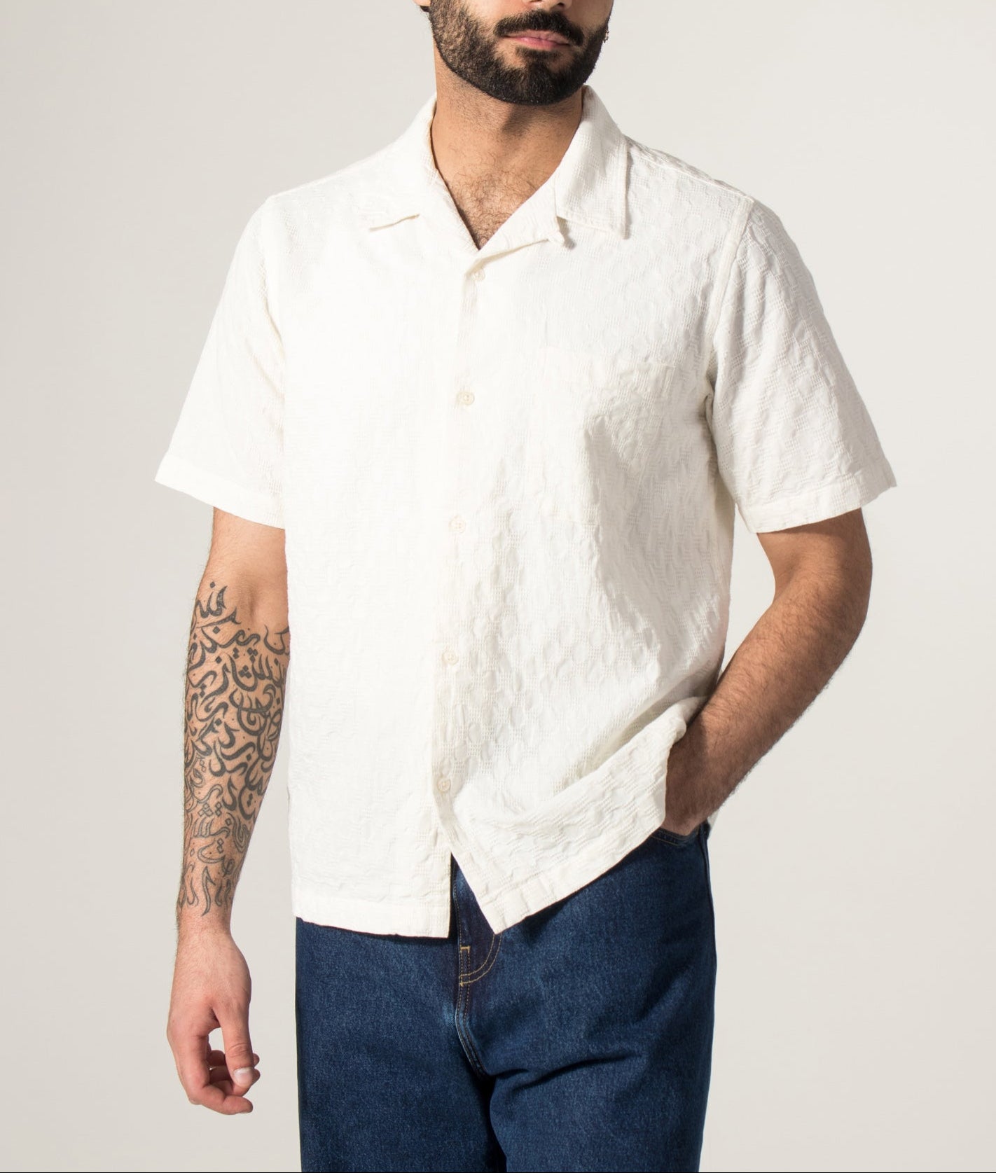 Universal Works Short Sleeve Seersucker Road Shirt in Ecru at EQVVS Menswear. Model front shot.