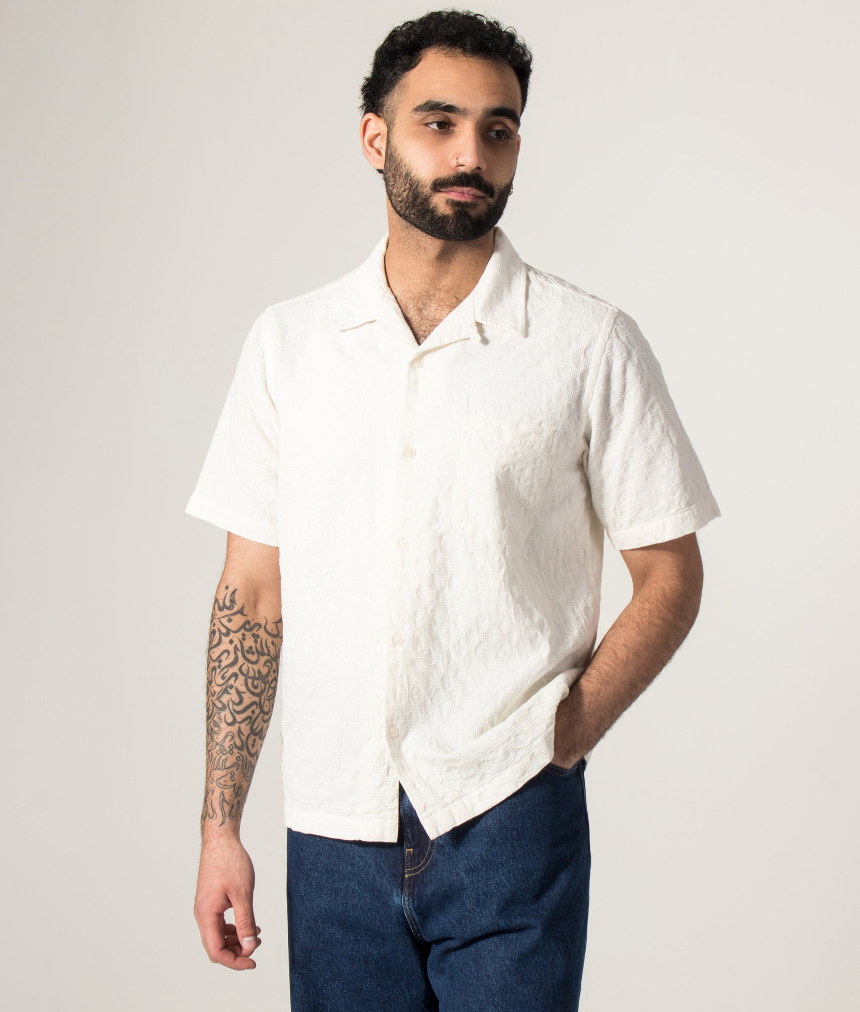 Universal Works Short Sleeve Seersucker Road Shirt in Ecru at EQVVS Menswear. Model front shot.