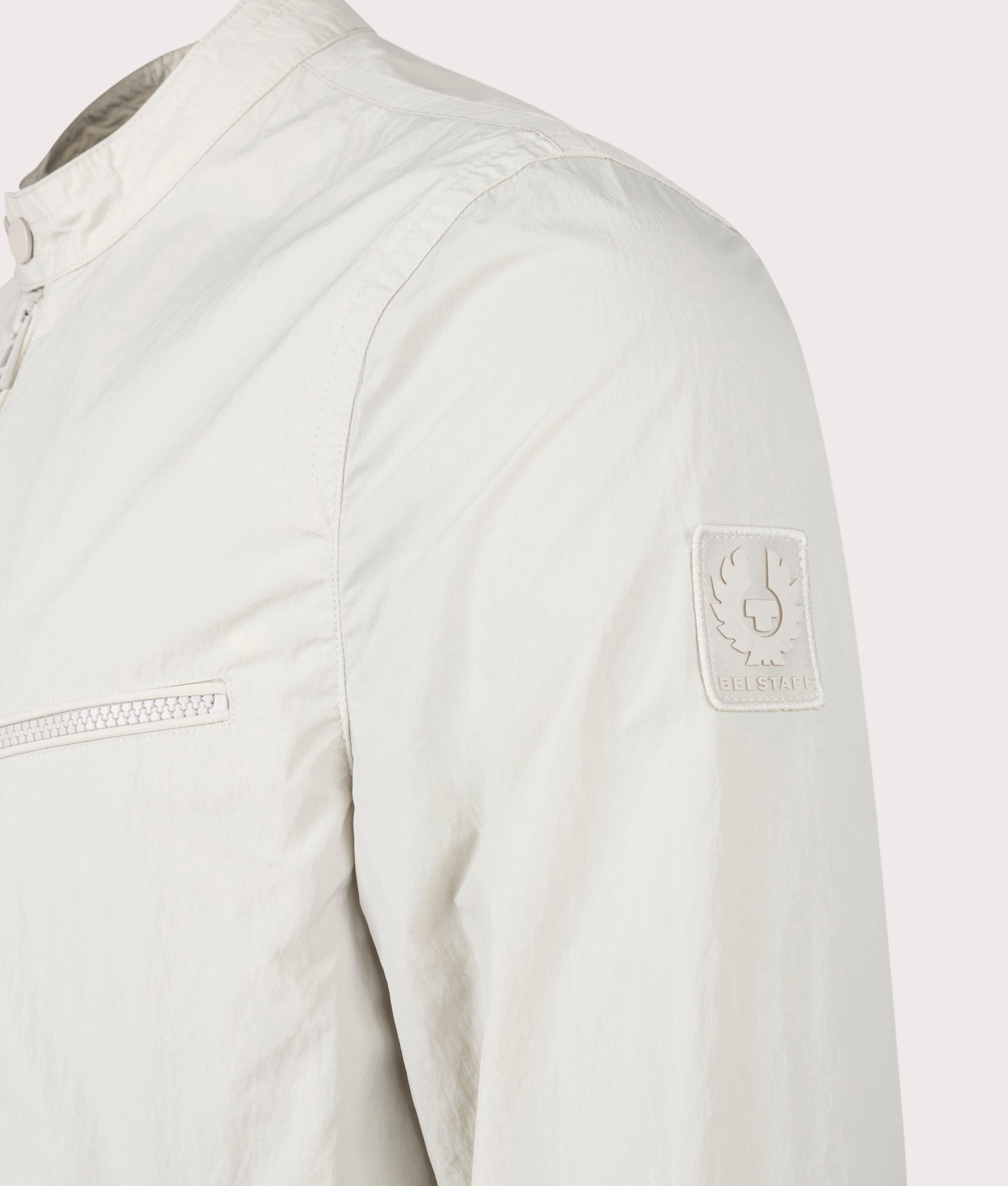Belstaff Walkham Jacket in Stone Beige at EQVVS. Detailed logo shot. 
