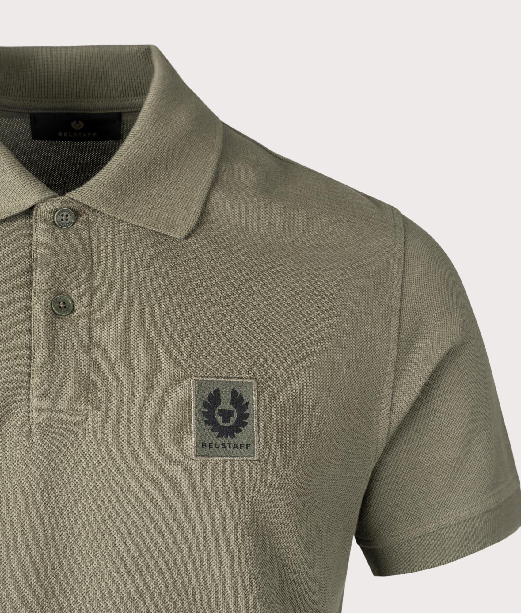 Belstaff Polo Shirt in Surplus Green, 100% Cotton. At EQVSS Menswear. Front logo shot.  
