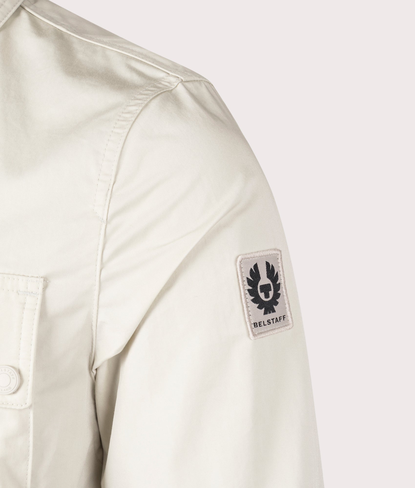 Belstaff Drome Overshirt in Stone Beige, Cotton/Nylon blend. At EQVVS Menswear. Front angle logo shot