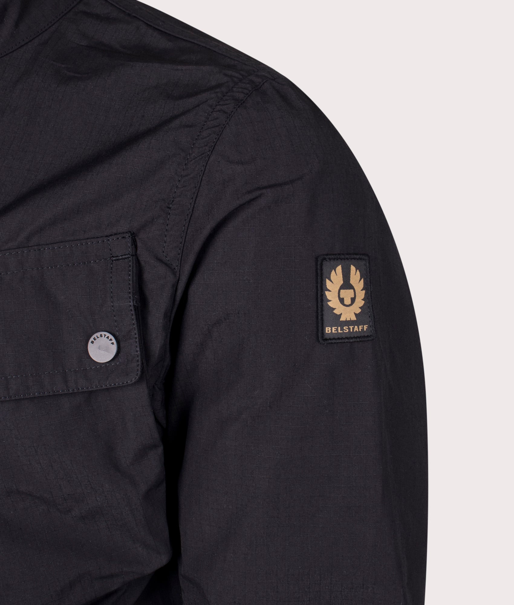 Belstaff Service Racemaster Jacket in Black at EQVVS. Detailed logo shot. 