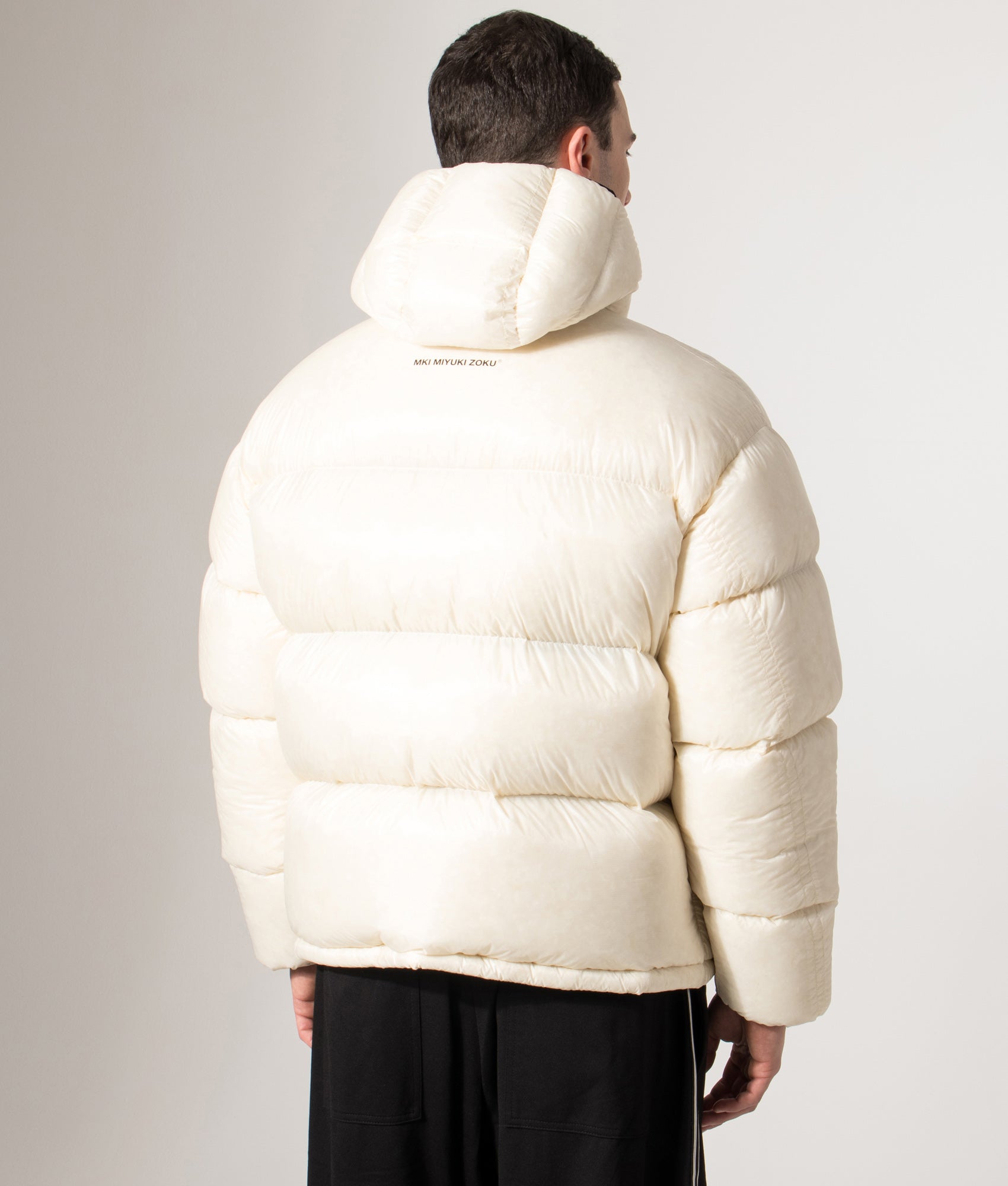 MKI MIYUKI ZOKU Translucent Bubble Jacket in Off White at EQVVS Menswear. Back model shot.