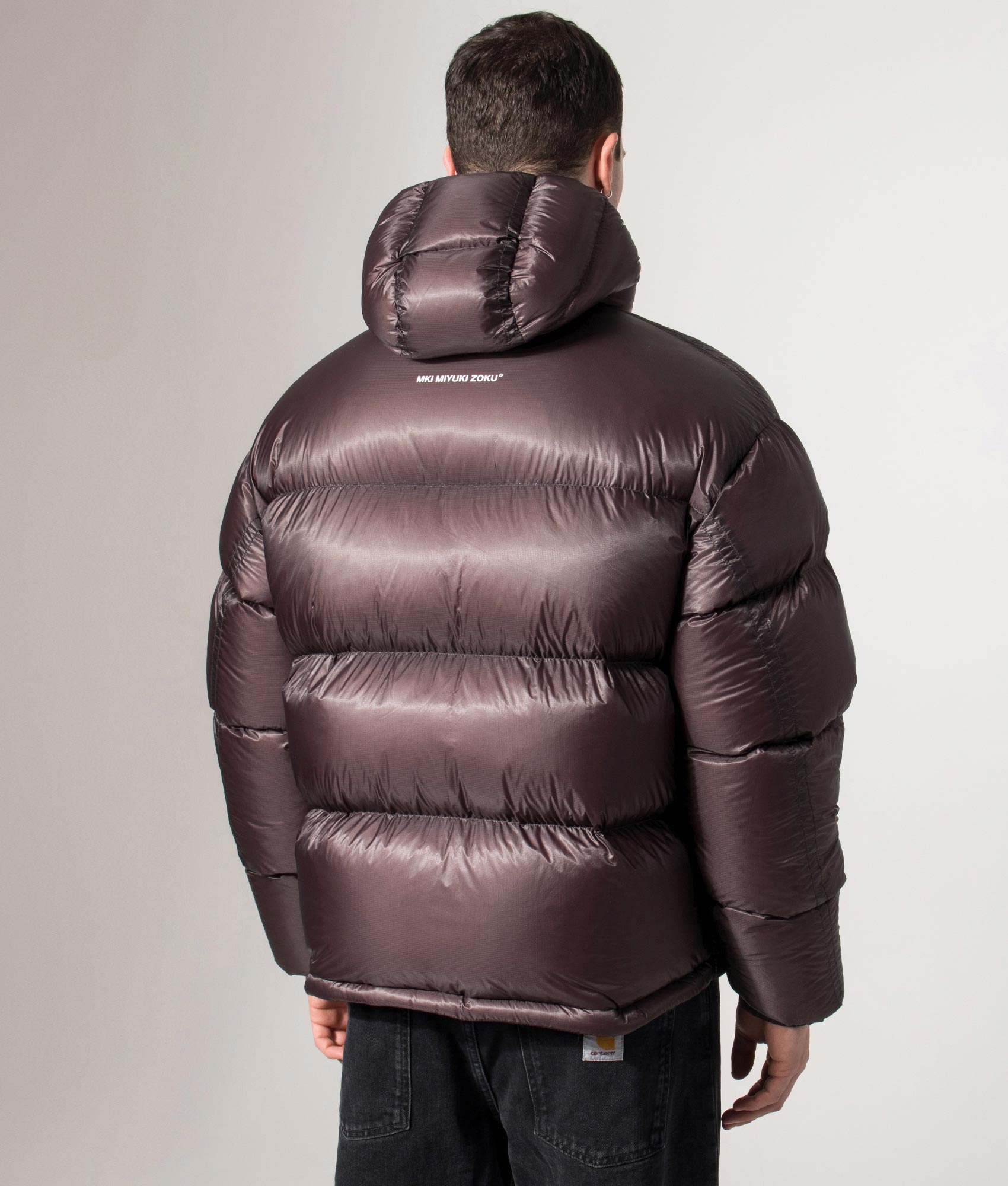 MKI MIYUKI ZOKU Translucent Hooded Bubble Jacket in Raisin at EQVVS Menswear. Back model shot.