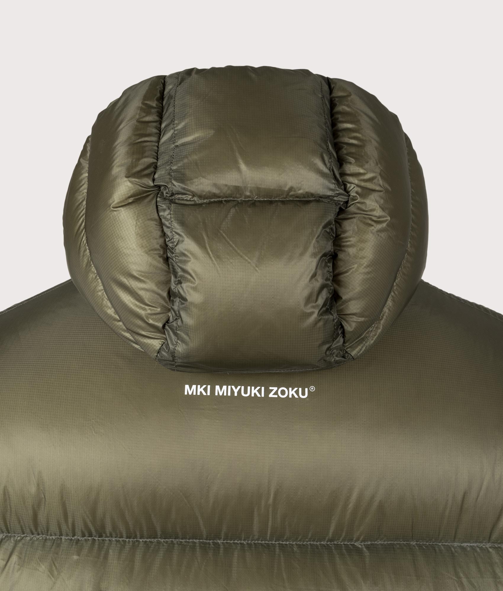 MKI MIYUKI ZOKU Translucent Bubble Jacket in Olive at EQVVS Menswear. Detail shot.