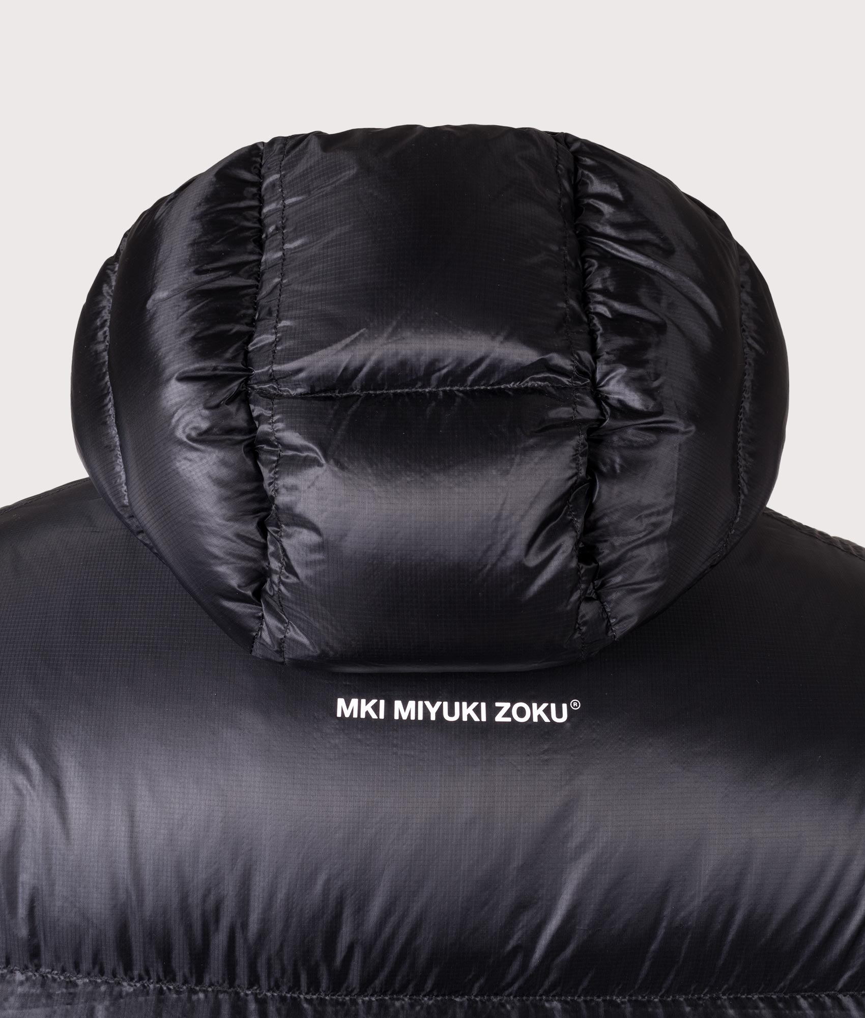 MKI MIYUKI ZOKU Translucent Hooded Bubble jacket in Black at EQVVS Menswear. Detail shot.