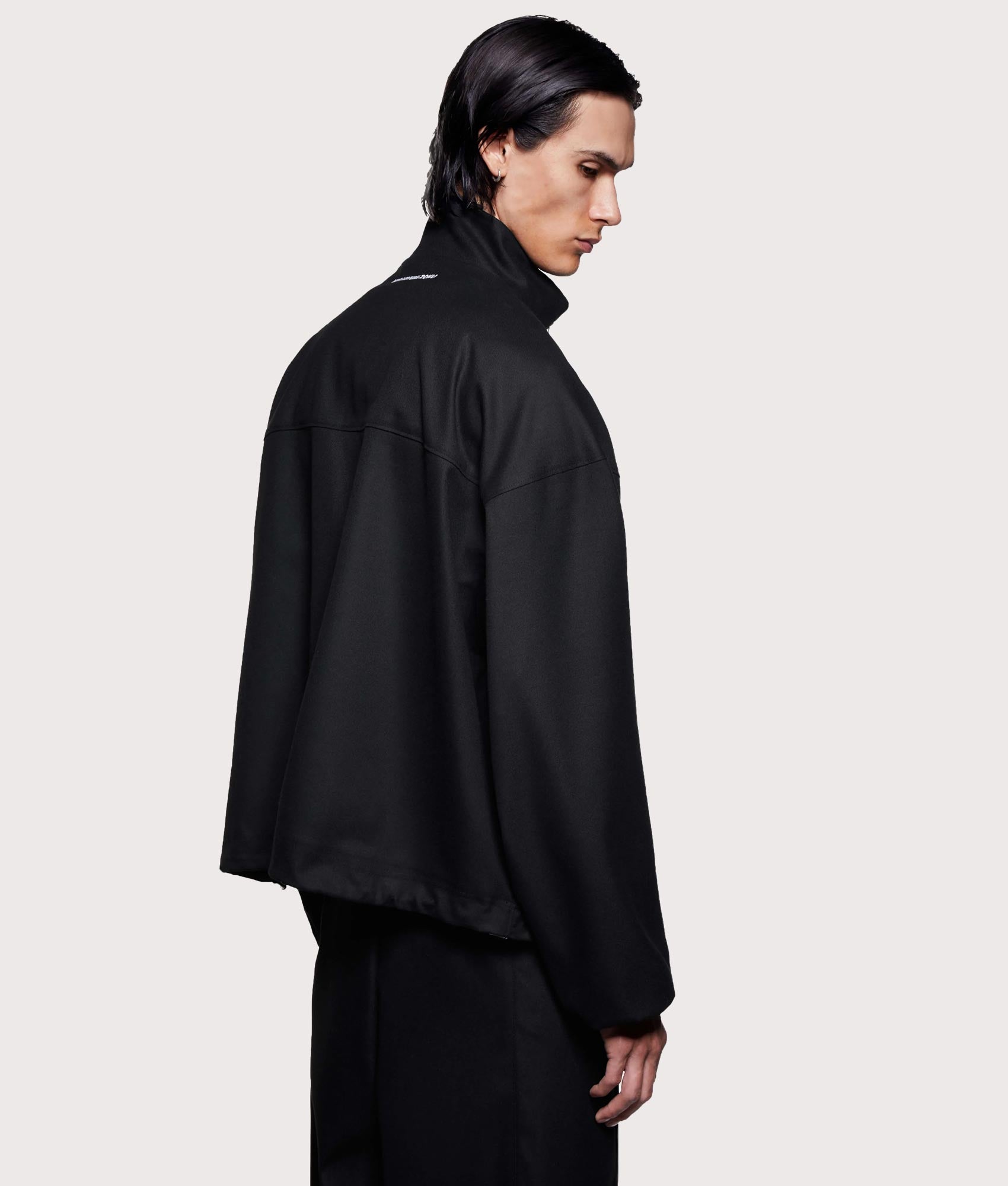 MKI MIYUKI ZOKU Suiting Quarter zip Sweatshirt in Black at EQVVS Menswear. Angled model back shot.