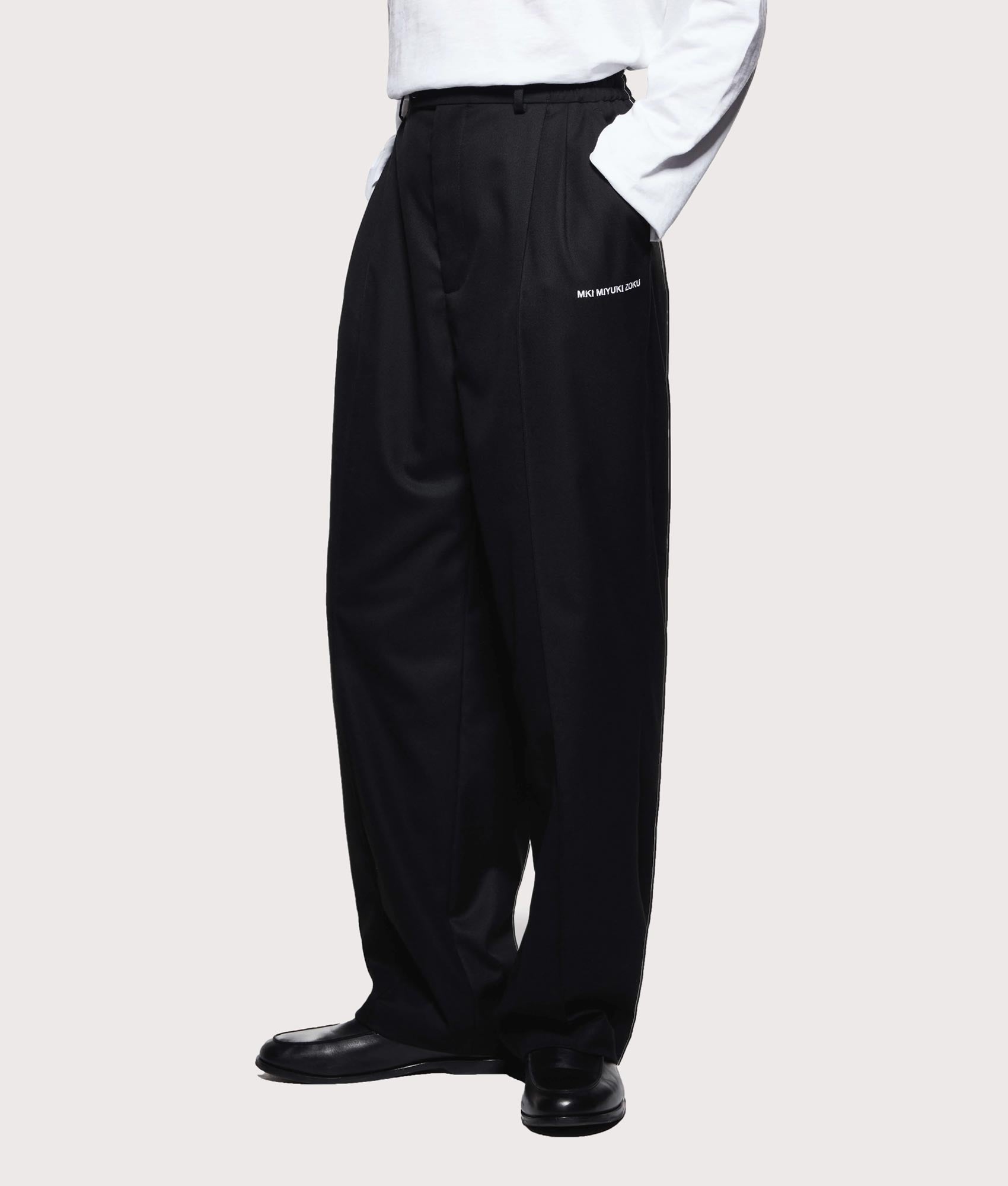 MKI MIYUKI ZOKU V2 Wide Leg Suit Pants in black at EQVVS Menswear. Angled front shot.
