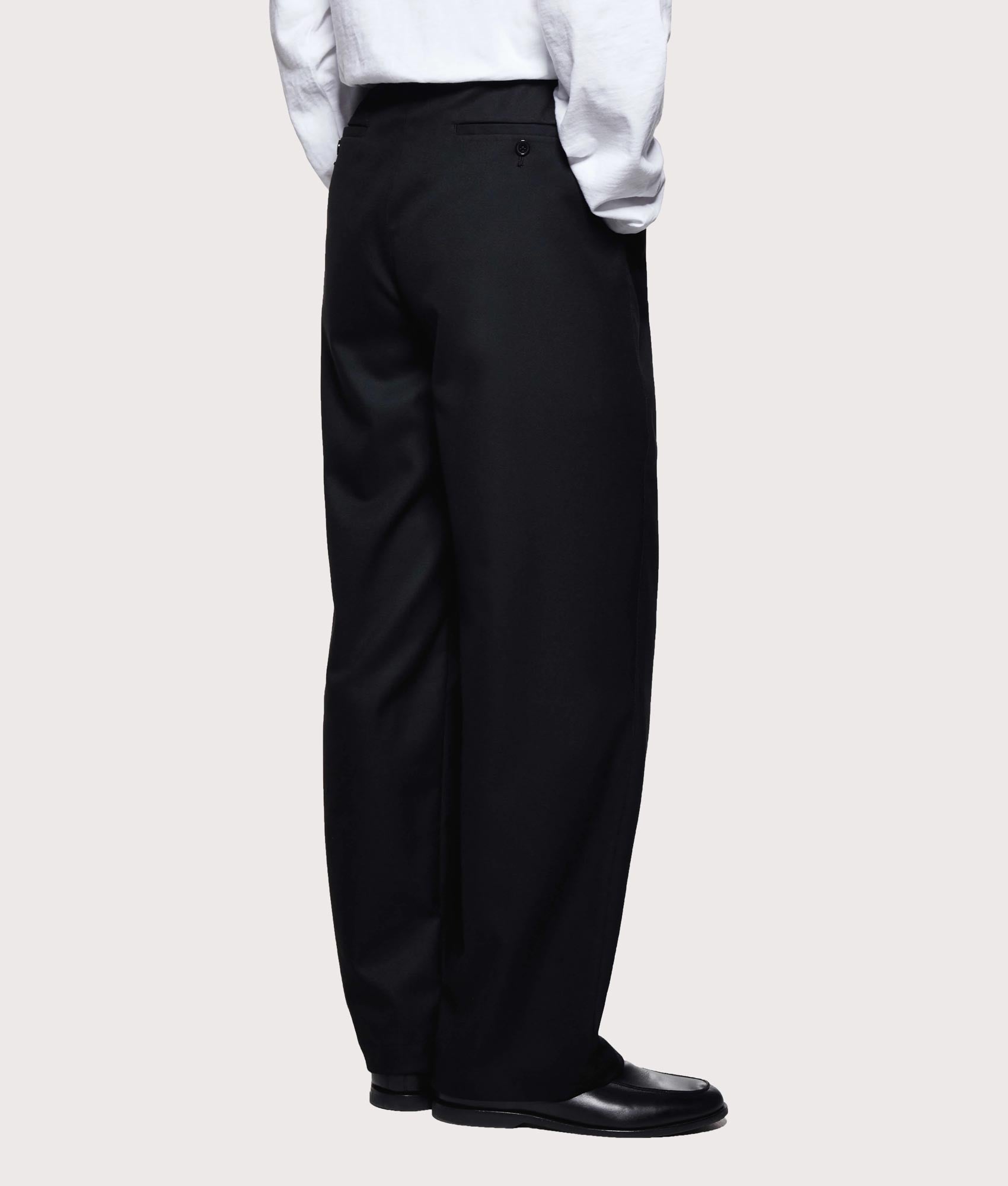 MKI MIYUKI ZOKU V2 Wide Leg Suit Pants in black at EQVVS Menswear. Angled back shot.