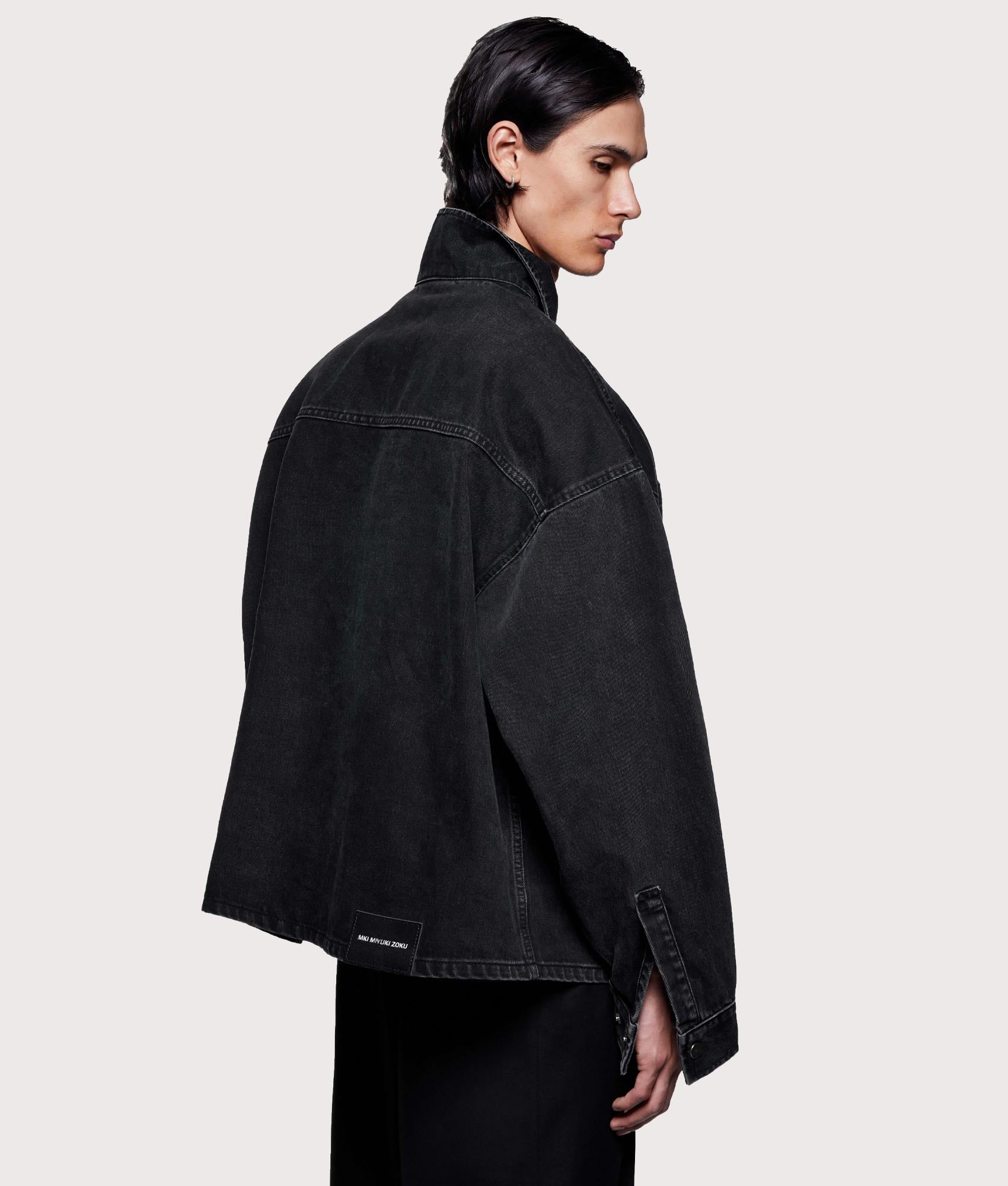 MKI MIYUKI ZOKU Denim Box Overshirt in Black Wash at EQVVS Menswear. Model back shot.
