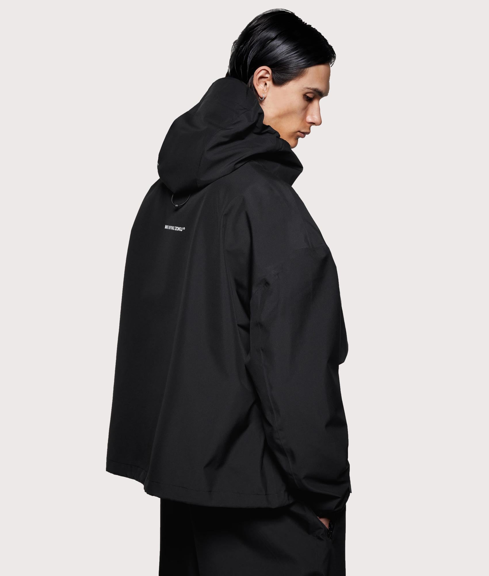 MKI MIYUKI ZOKU Shell Box Jacket in Black at EQVVS Menswear. Angled model back shot. 