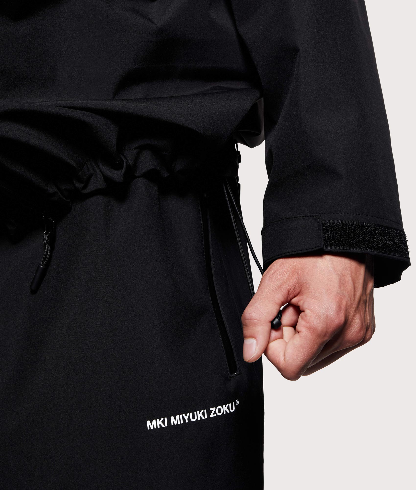 MKI MIYUKI ZOKU Shell Box Jacket in Black at EQVVS Menswear. Hem detail shot.