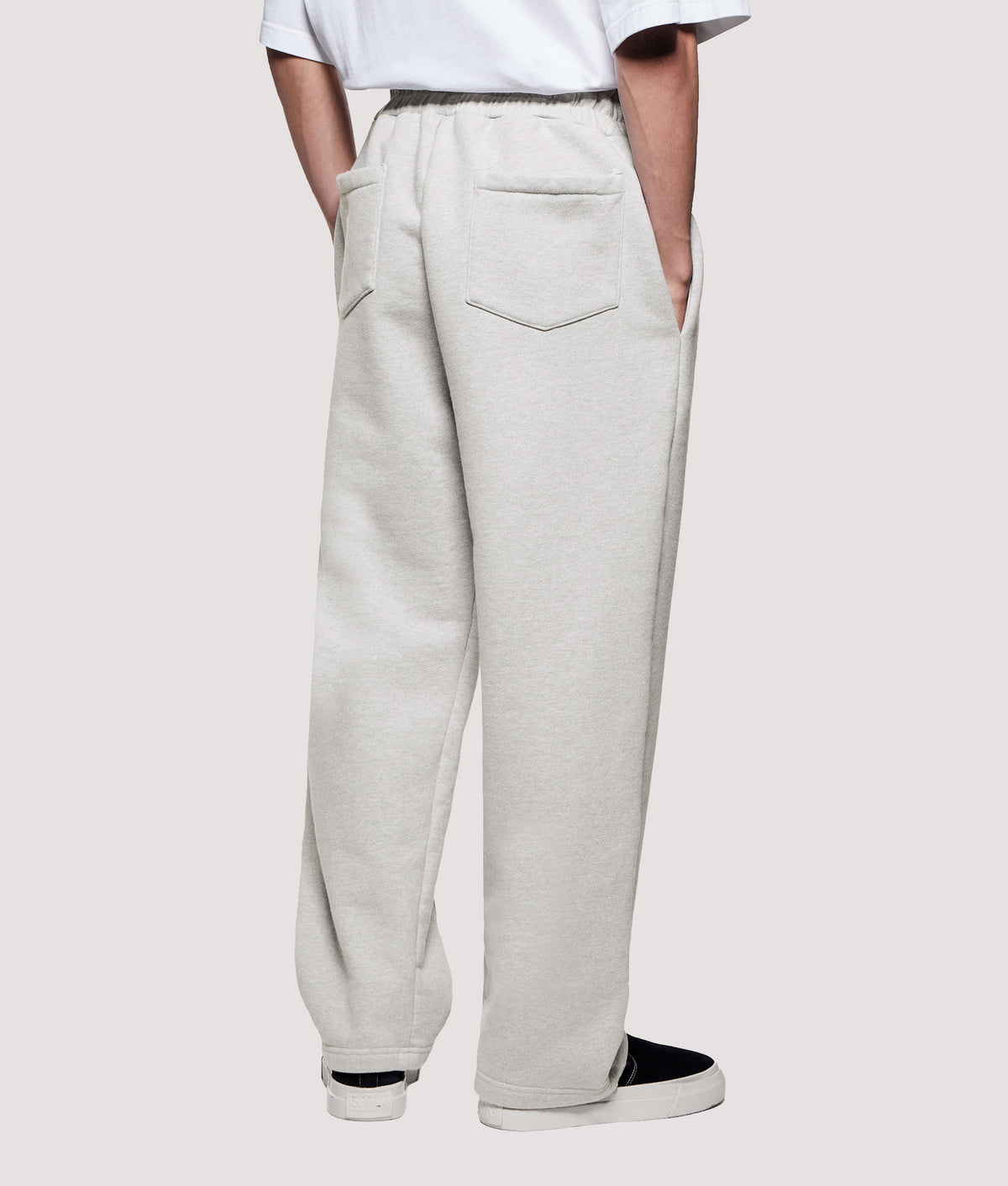 MKI MIYUKI ZOKU Relaxed Fit 800 GSM Superweight Wide Leg Joggers in Oatmeal at EQVVS Menswear. Angled model back shot.