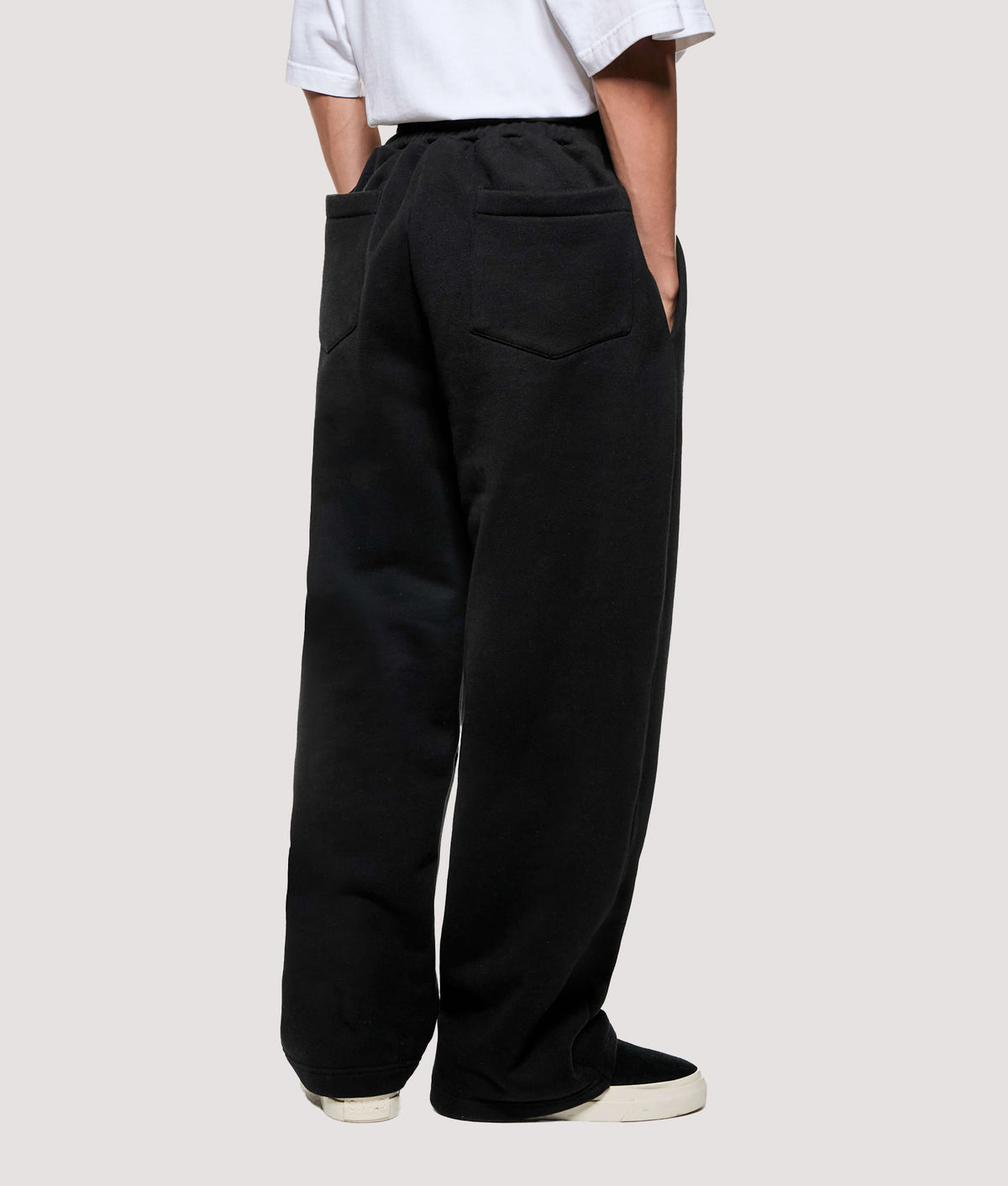 MKI MIYUKI ZOKU Relaxed Fit 800 GSM Superweight Wide Leg Joggers in Black at EQVVS Menswear. Angled model back shot.