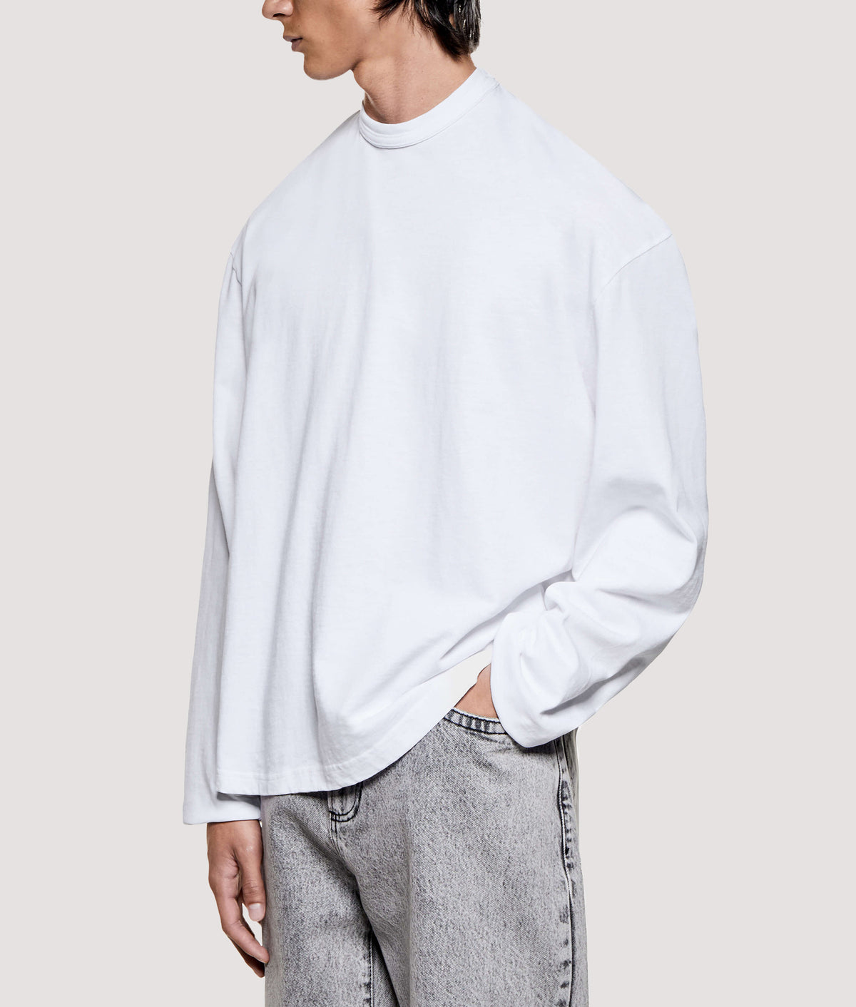 MKI MIYUKI ZOKU Relaxed Fit 220 GSM Slub Long Sleeve T-Shirt in White at EQVVS Menswear. Model angled front shot.