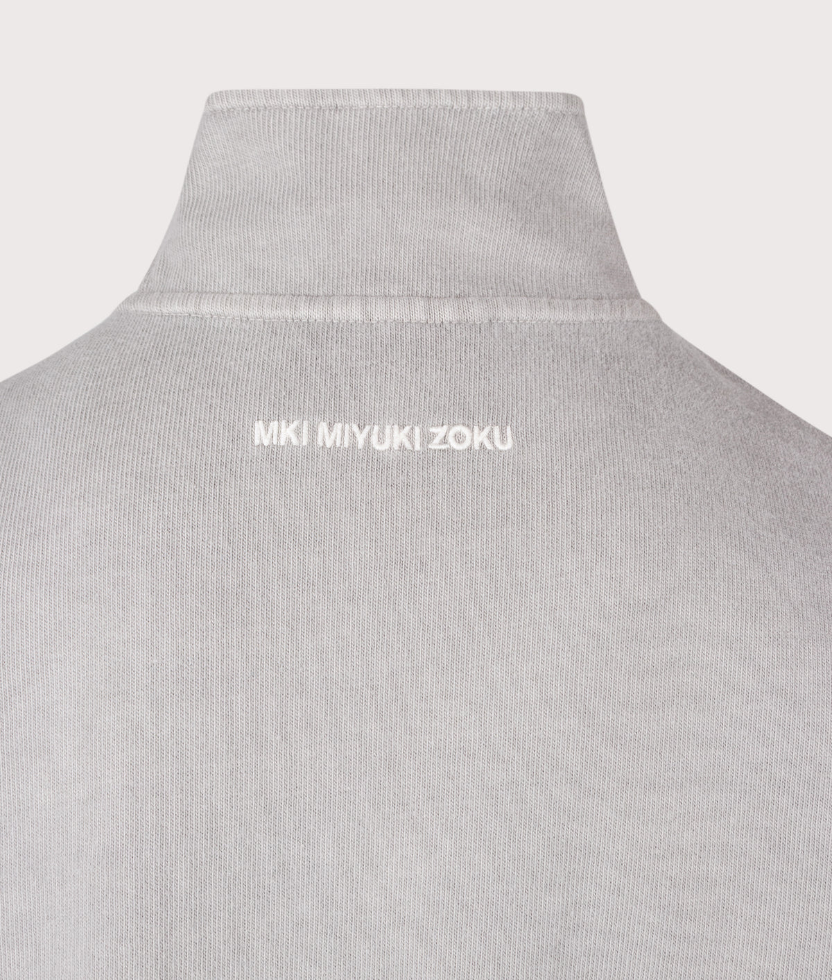 MKI MIYUKI ZOKU Relaxed Fit 400 GSM Pigment Dyed Track Jacket in Pigment Stone at EQVVS Menswear. Back detail shot.
