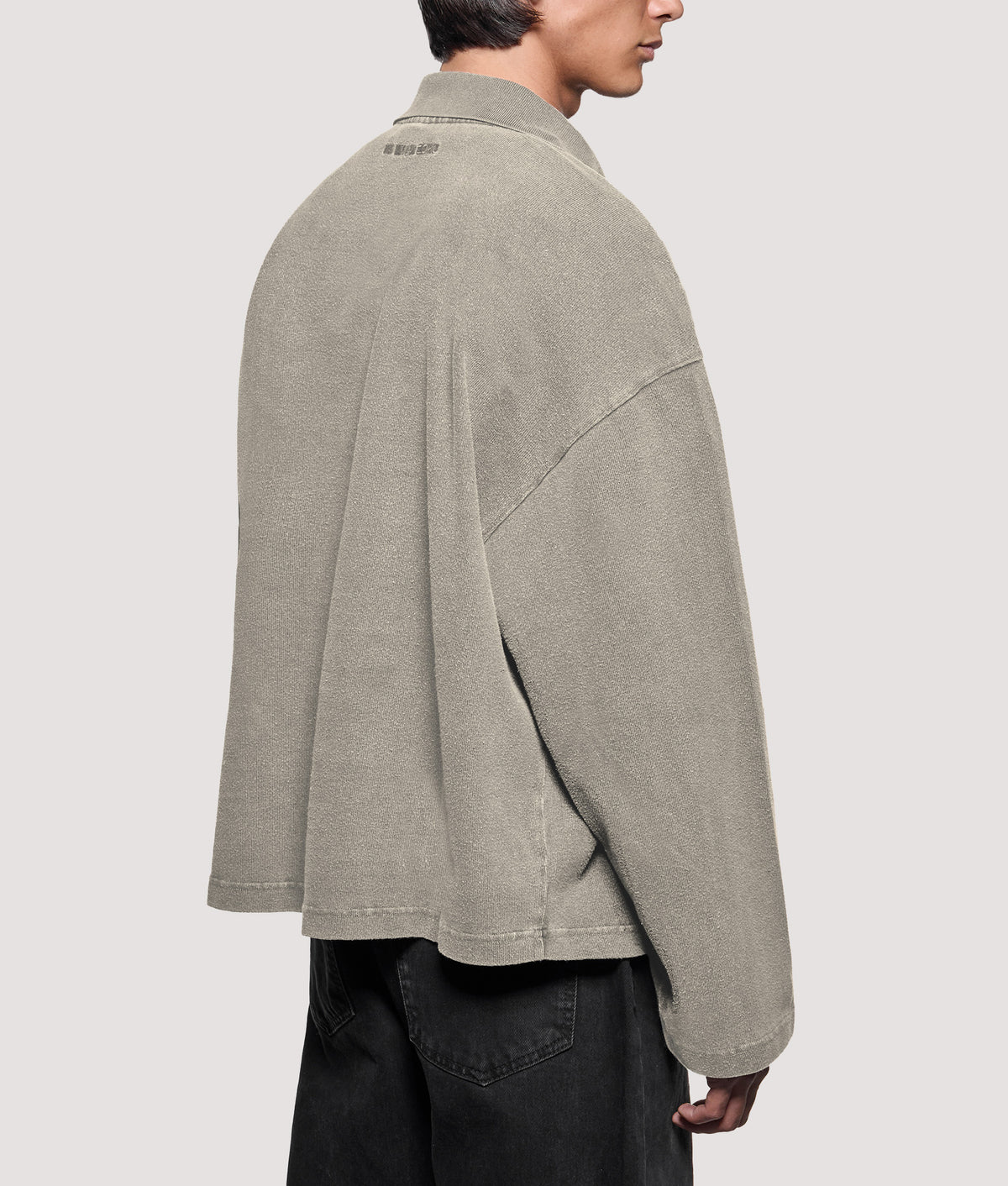 MKI MIYUKI ZOKU Relaxed Box Fit 400 GSM Pigment Dyed Rugby Shirt in Pigment Stone at EQVVS Menswear. Angled model back shot.