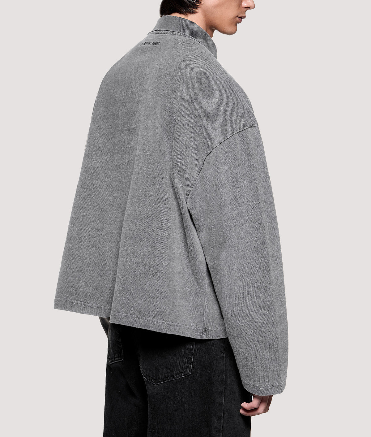 MKI MIYUKI ZOKU Relaxed Box Fit 400 GSM Pigment Dyed Rugby Shirt in Pigment Black at EQVVS Menswear. Angled model back shot.