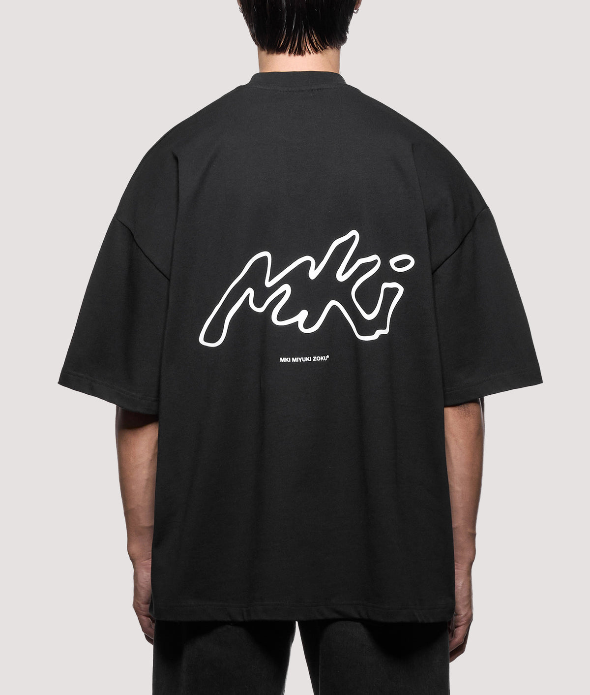 MKI MIYUKI ZOKU Oversized Box Fit Ink Line T-Shirt in Black at EQVVS Menswear. Model back shot.