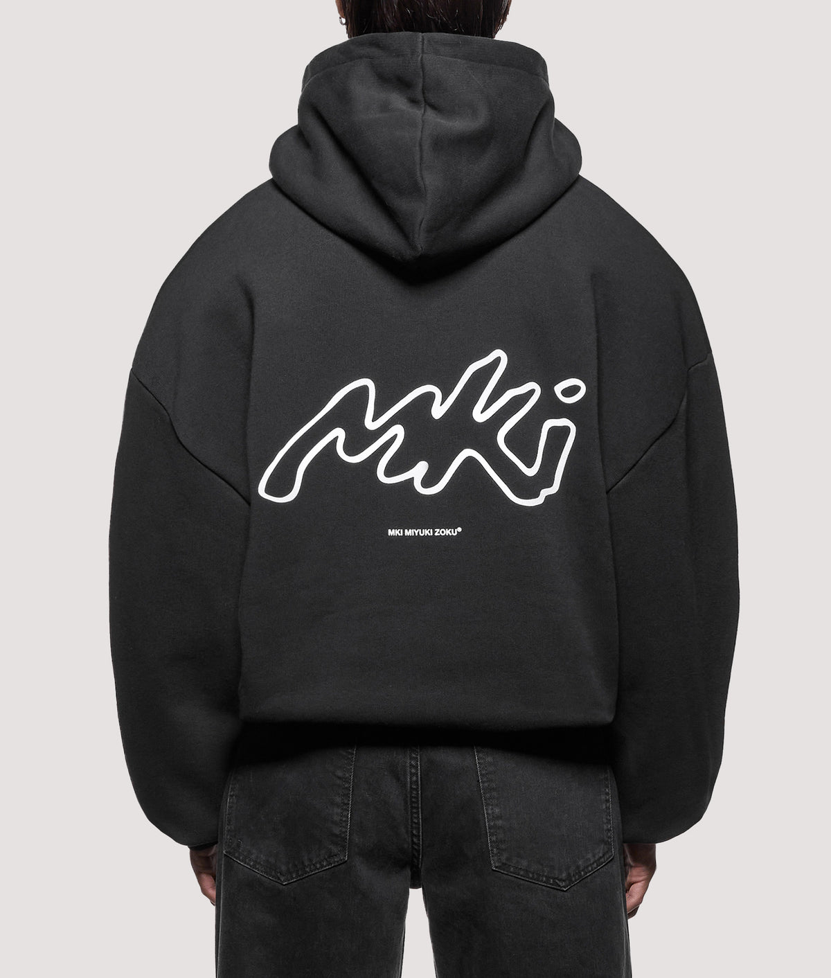 MKI MIYUKI ZOKU Oversized Box Fit Ink Line Hoodie in Black at EQVVS Menswear. Model back shot.