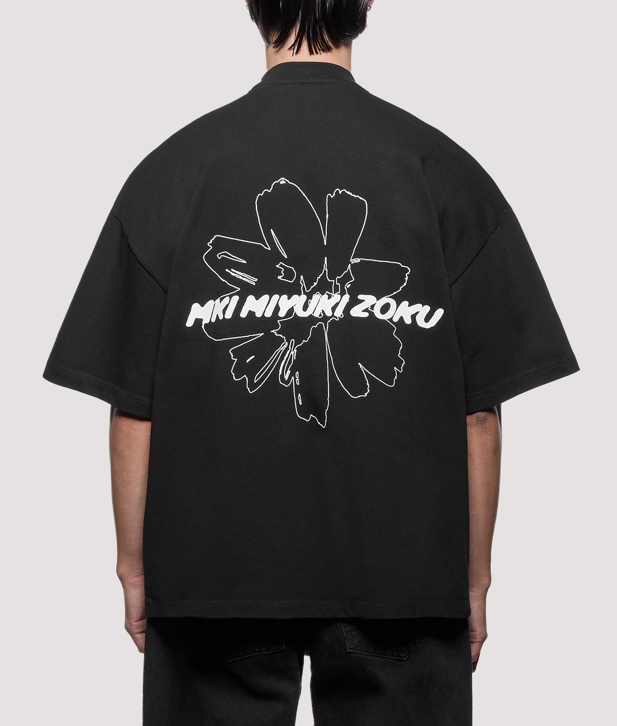 MKI MIYUKI ZOKU Oversized Box Fit Wildflower T-Shirt in Black at EQVVS Menswear. Model back shot.