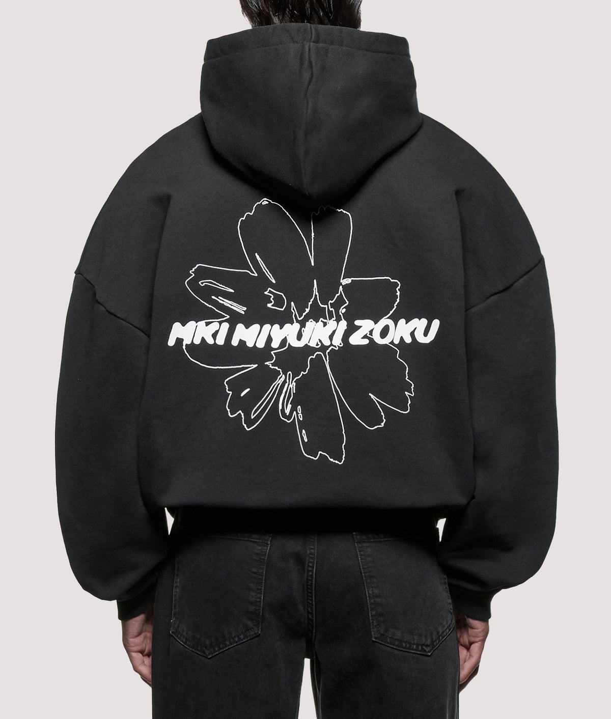 MKI MIYUKI ZOKU Oversized Box Fit Wildflower Hoodie in Black at EQVVS Menswear. Model back shot.