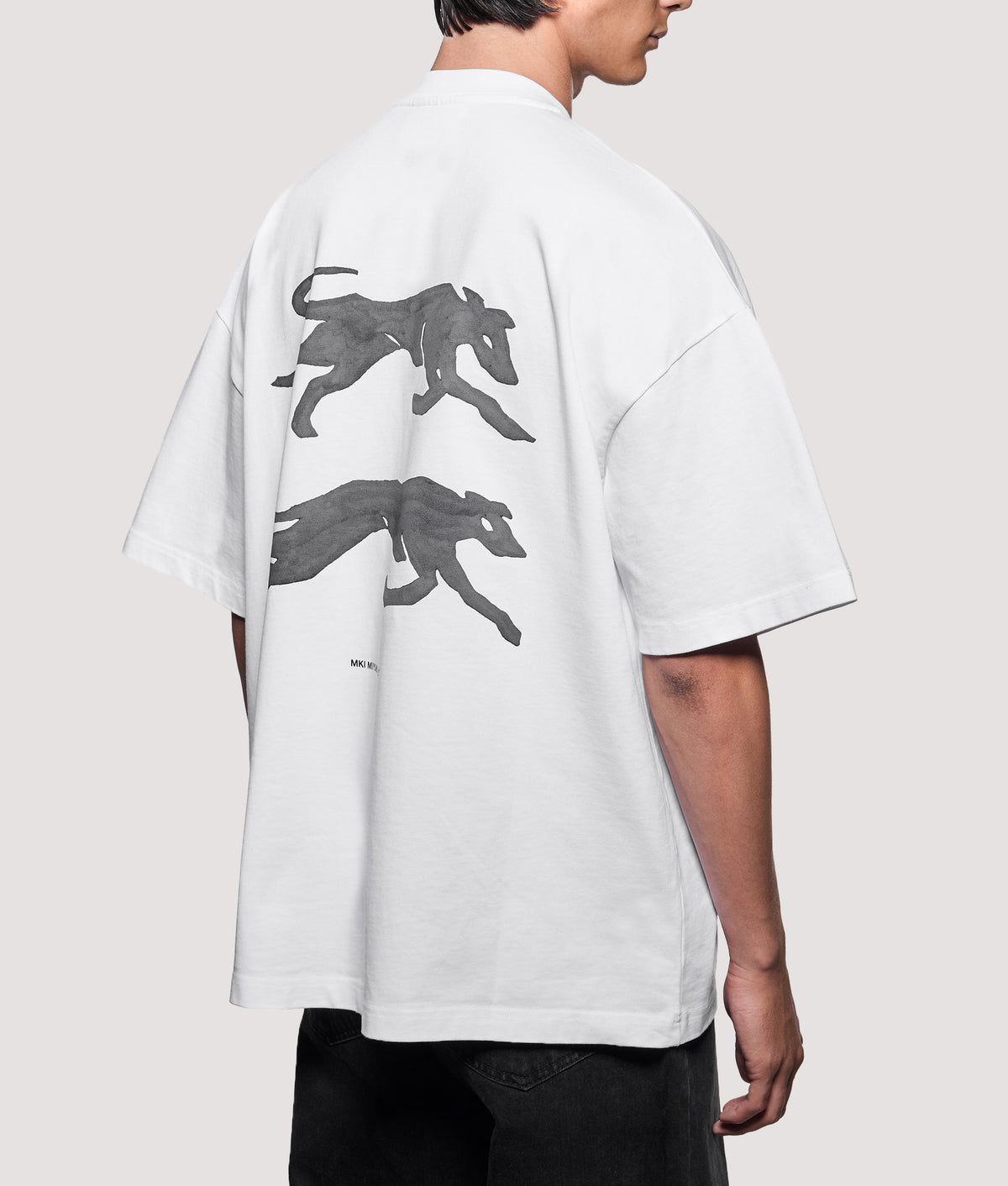 MKI MIYUKI ZOKU Oversized Box Fit Greyhound T-Shirt in White at EQVVS Menswear. Angled model back shot.