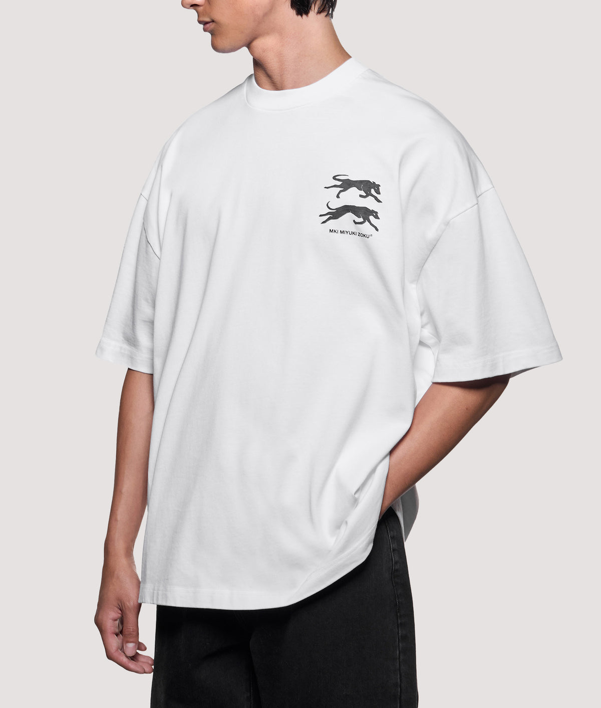 MKI MIYUKI ZOKU Oversized Box Fit Greyhound T-Shirt in White at EQVVS Menswear. Angled model front shot.