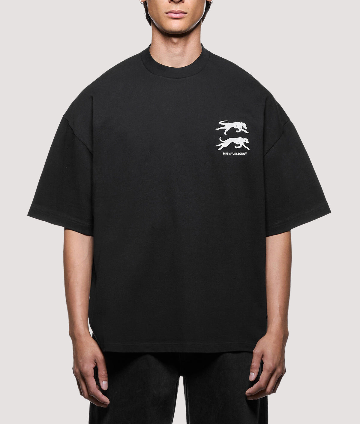 MKI MIYUKI ZOKU Oversized Box Fit Greyhound T-Shirt in Black at EQVVS Menswear. Model front shot.